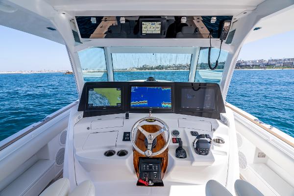2020 HCB 53 Sueños boat cockpit with advanced navigation screens on open water.