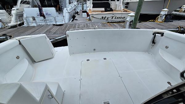 2000 Carver 450 Voyager Pilothouse boat deck at marina, featuring spacious seating area.