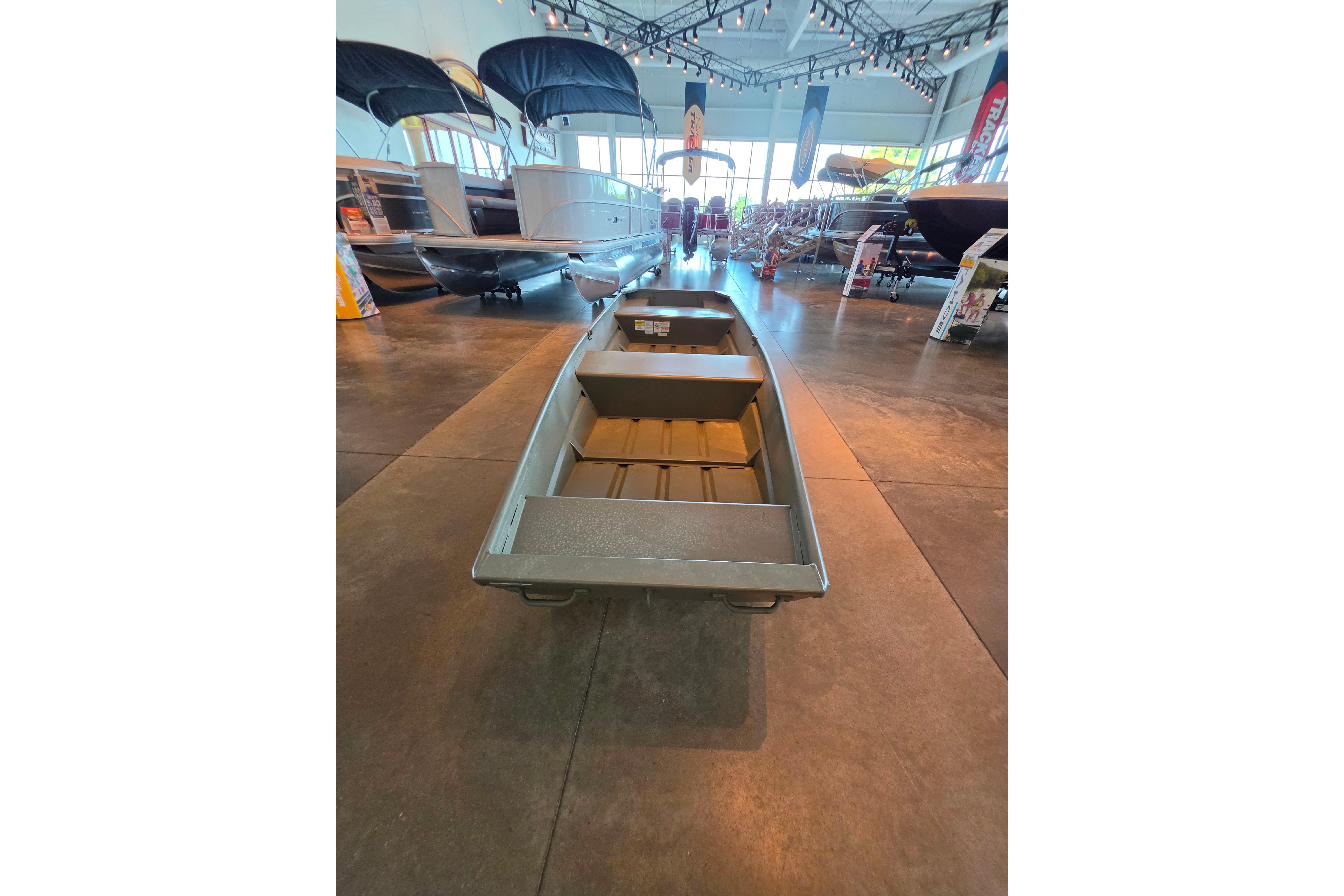 2026 Tracker Grizzly 10 Jon boat displayed in a showroom with other boats.