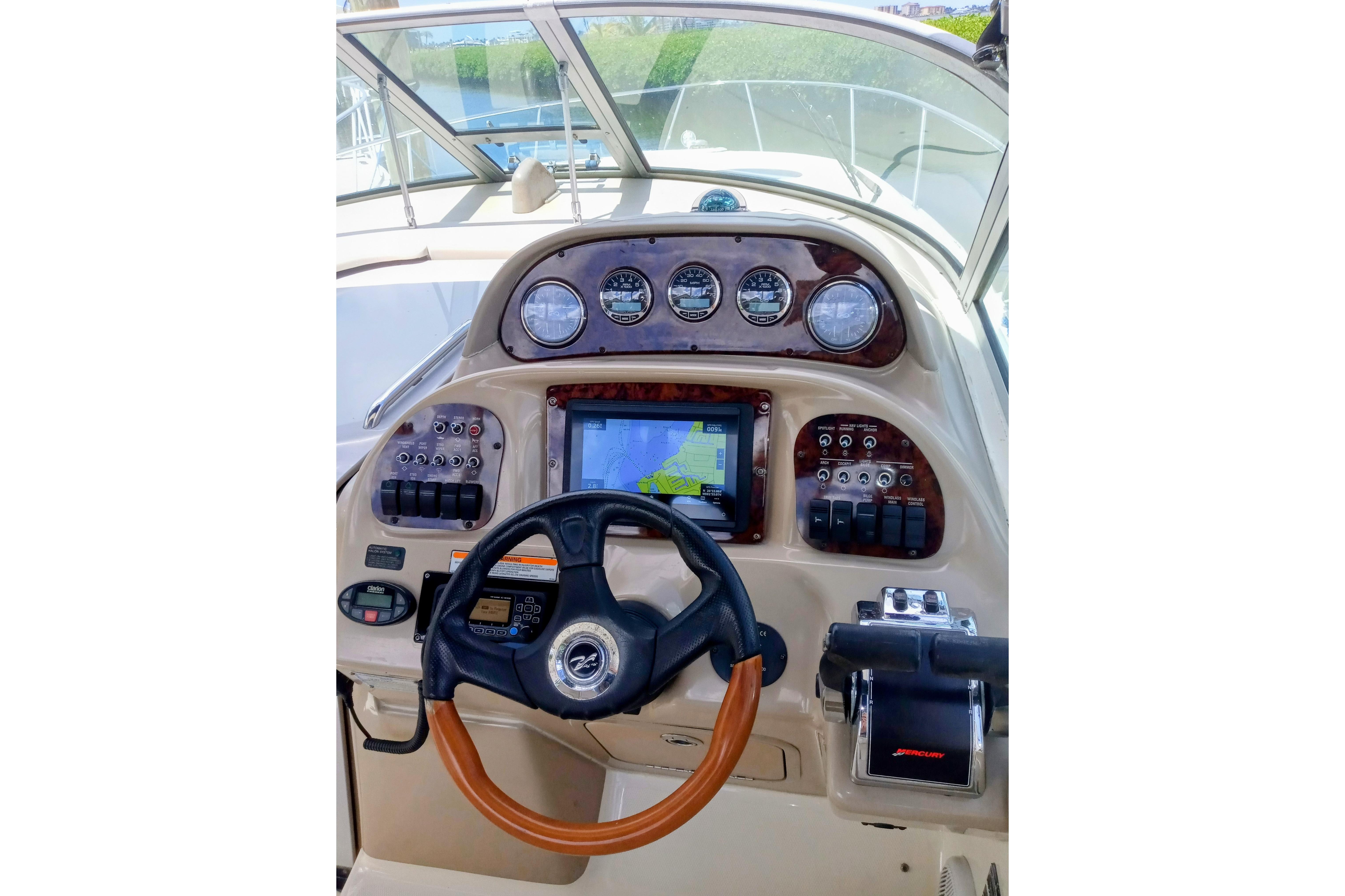 2005 Sea Ray 300 Sundancer helm with gauges, steering wheel, and navigation display.