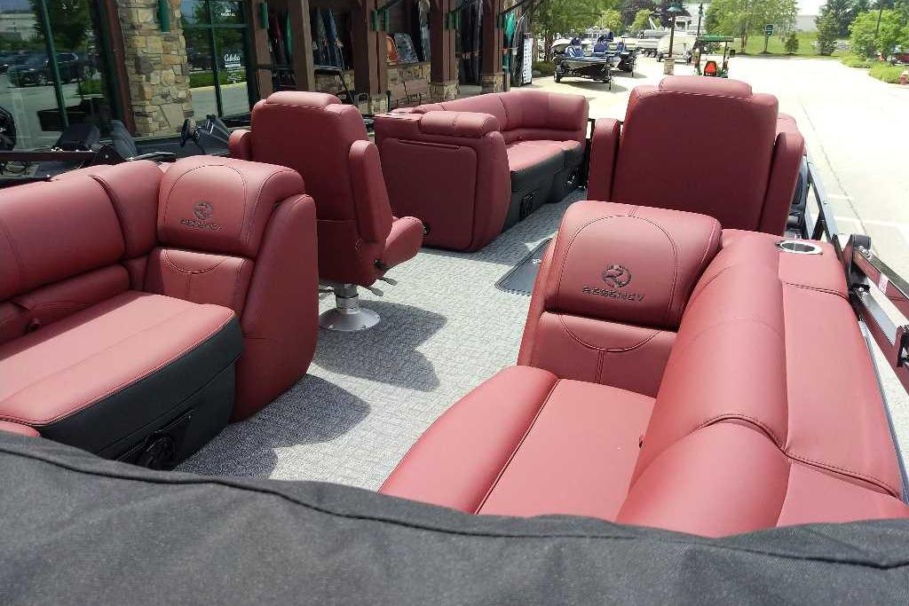 Luxurious 2026 Regency 230 DL pontoon boat with plush red seating and spacious layout.