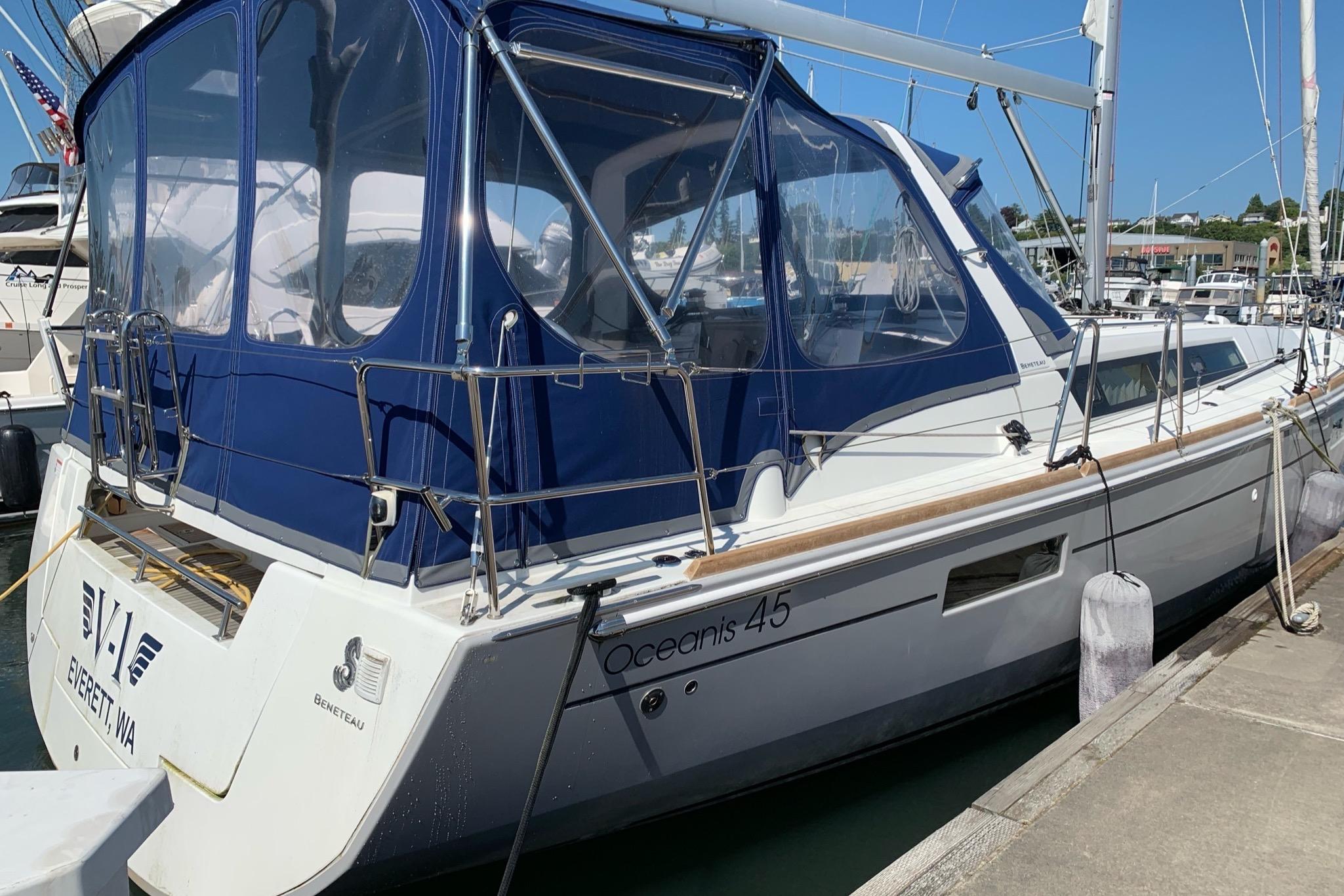 2018 Beneteau Oceanis 45 sailboat docked with blue canopy in marina.