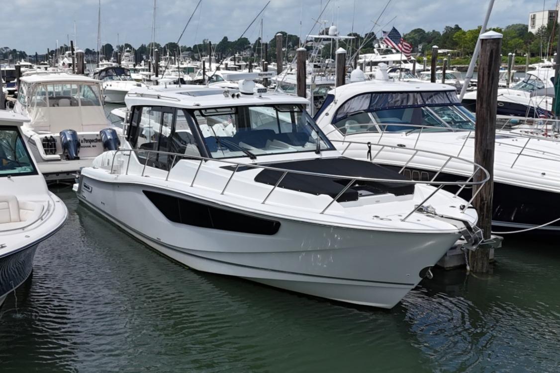 2021 Boston Whaler 405 Conquest docked in a marina, surrounded by other boats.