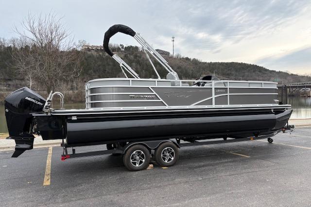 2025 Ranger Reata 243C pontoon boat on trailer, parked outdoors.