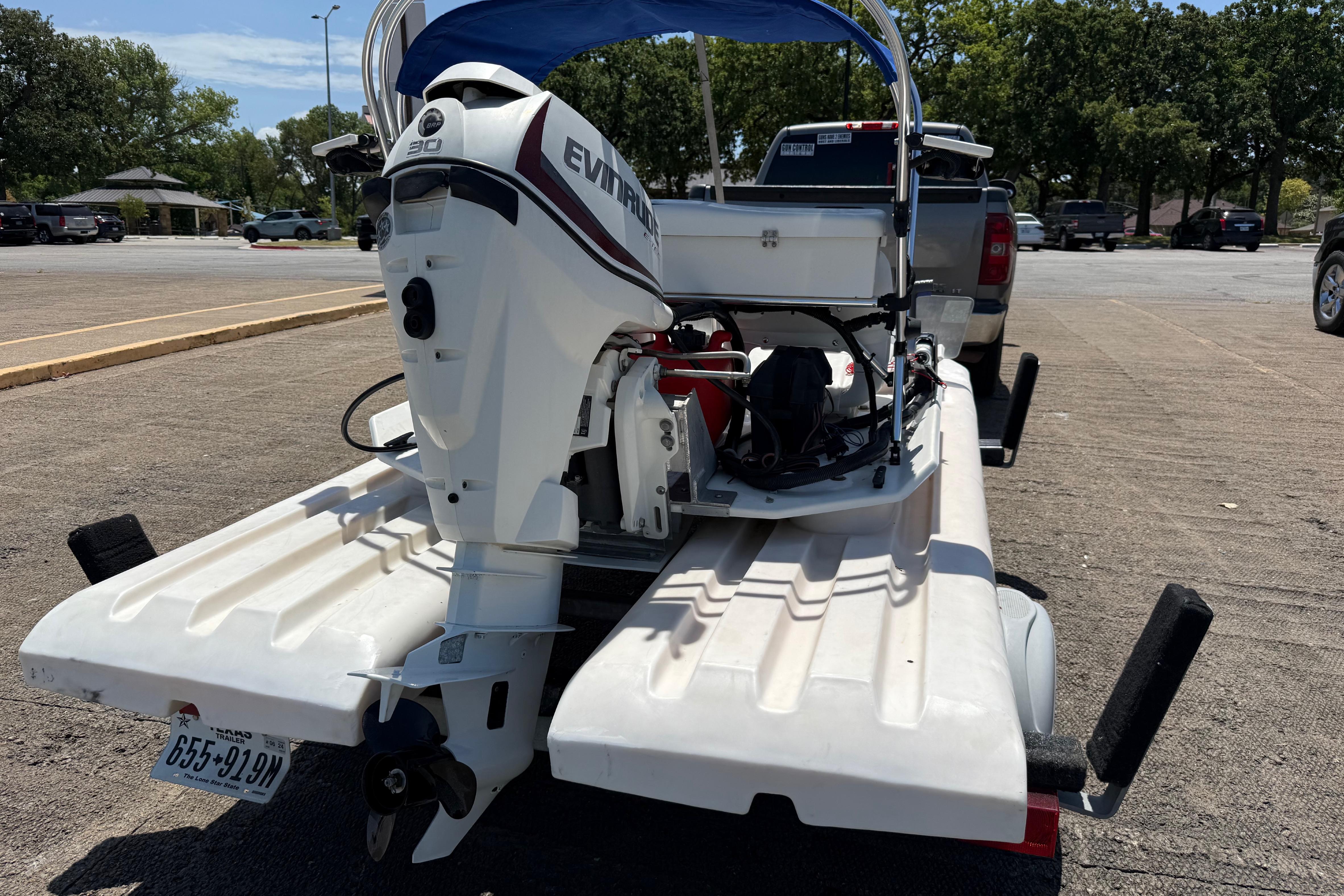 2016 CraigCat E2 Elite with Evinrude motor on trailer in parking lot.