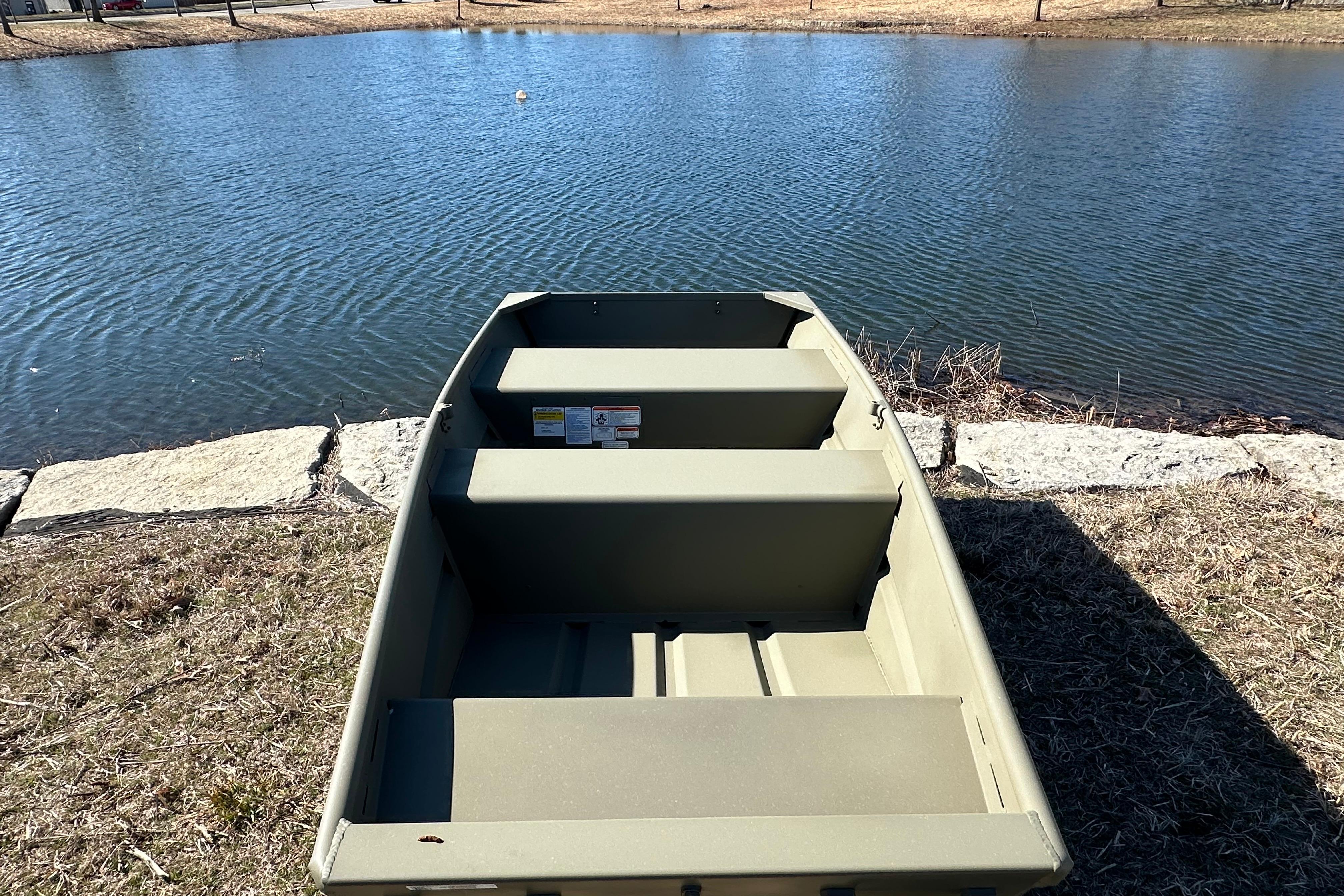 2026 Tracker Grizzly 10 Jon boat by a serene lake shore.