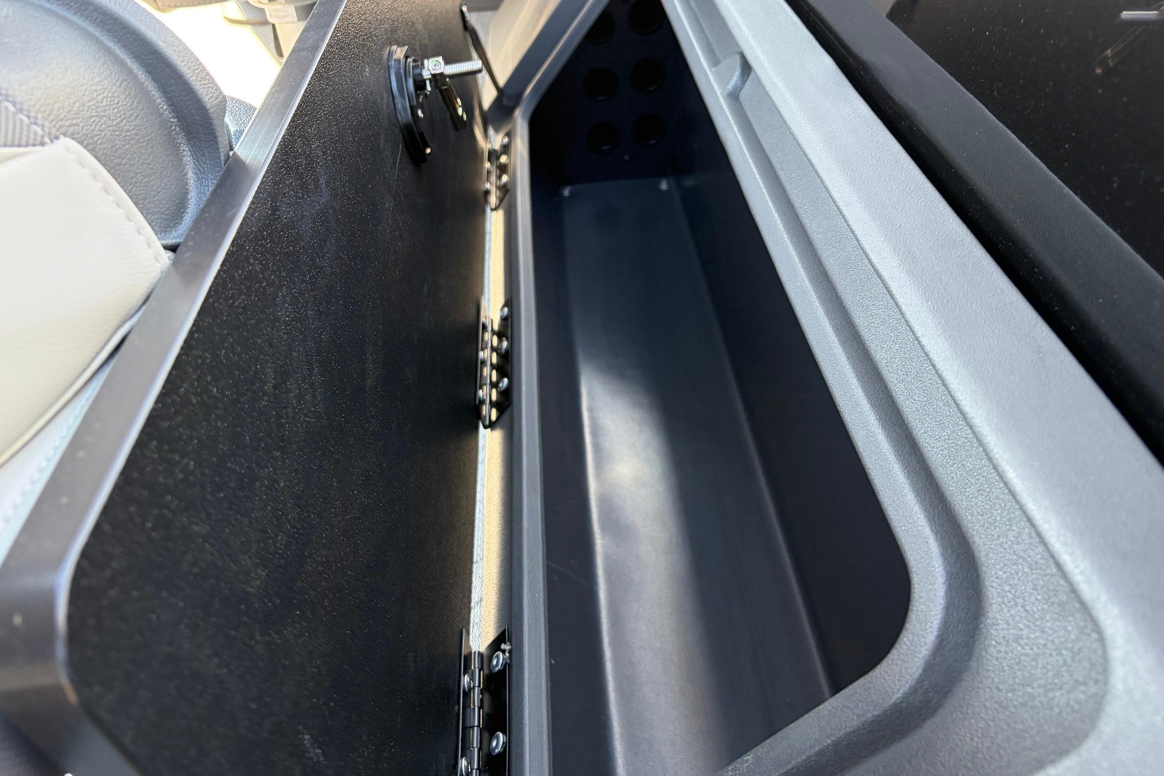 Storage compartment of 2026 Sun Tracker Fishin' Barge 22 XP3 boat, open and empty.