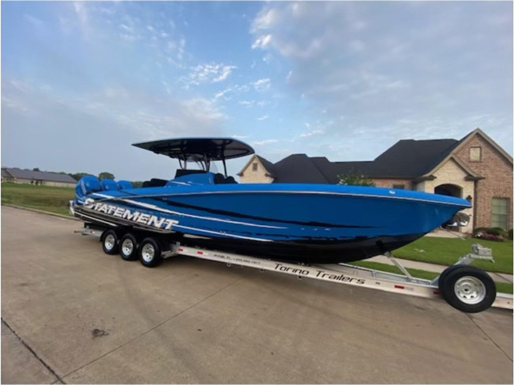 Blue 2021 Statement 380 Open boat on trailer in suburban neighborhood.