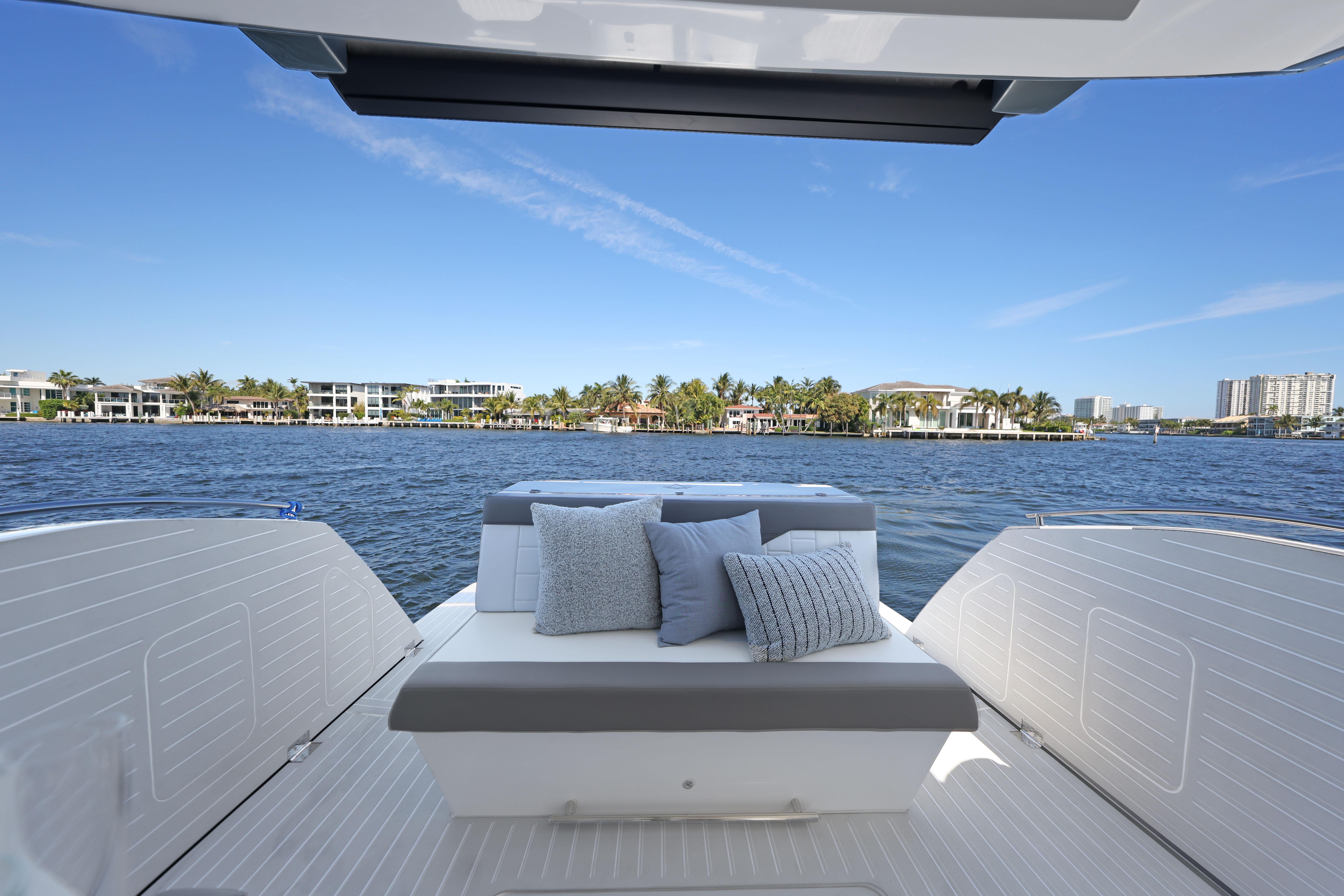 2025 Valiatt 380 Bowrider boat interior with cushions, overlooking waterfront homes and clear blue sky.