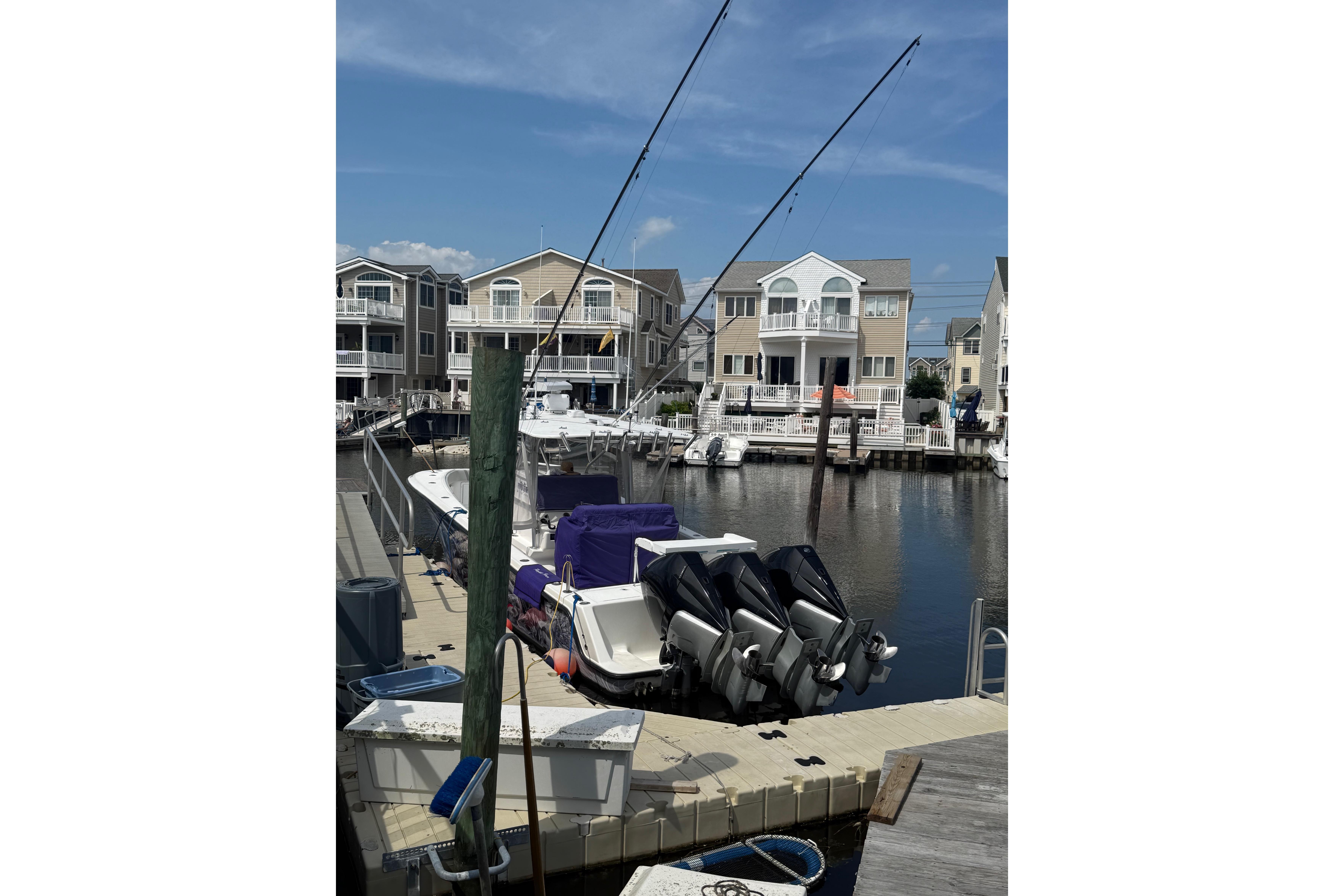 2006 SeaVee 340B boat docked in a marina with waterfront homes in the background.