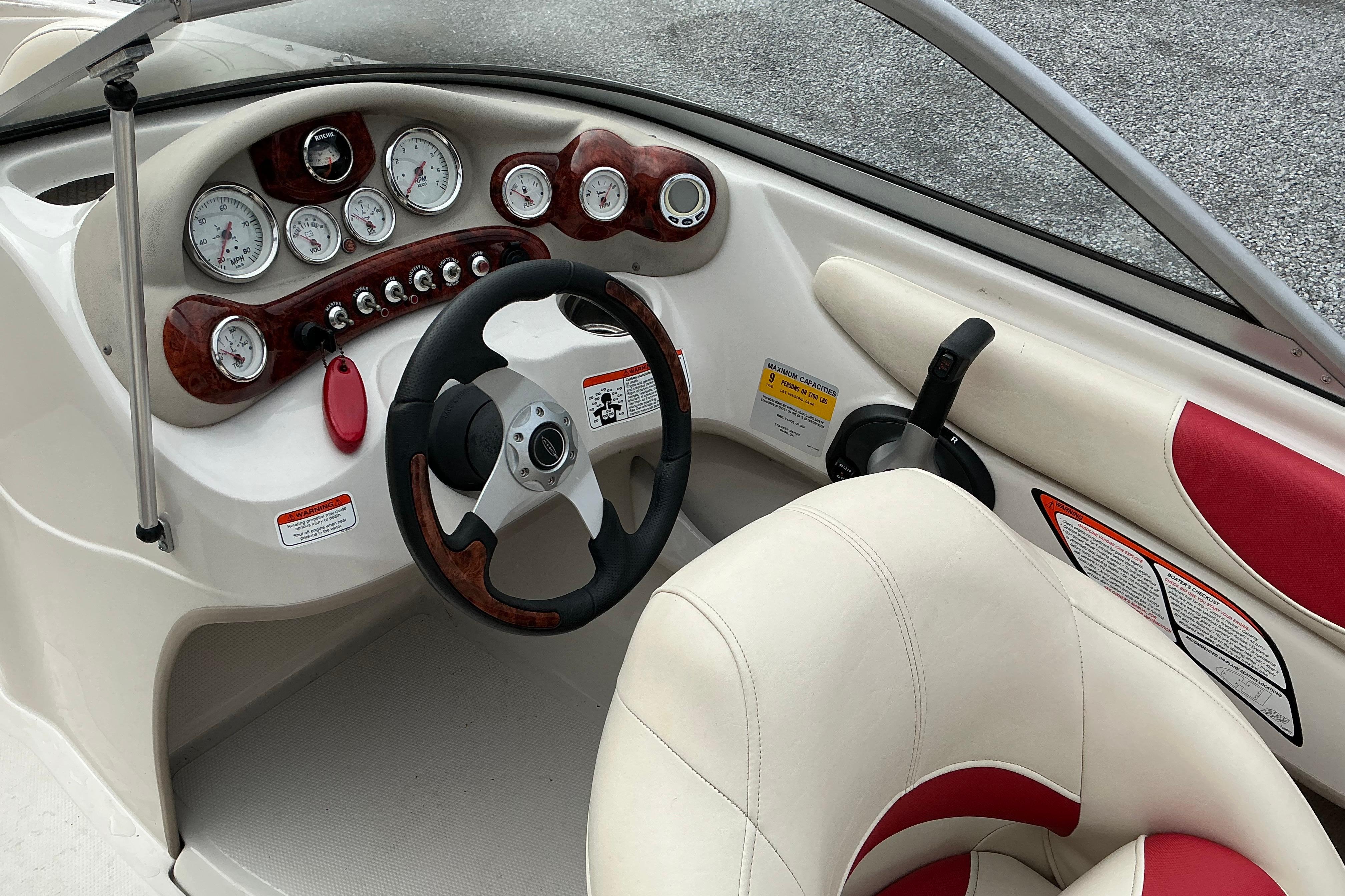 2014 Tahoe Q7i boat dashboard with gauges, steering wheel, and red-accented seating.