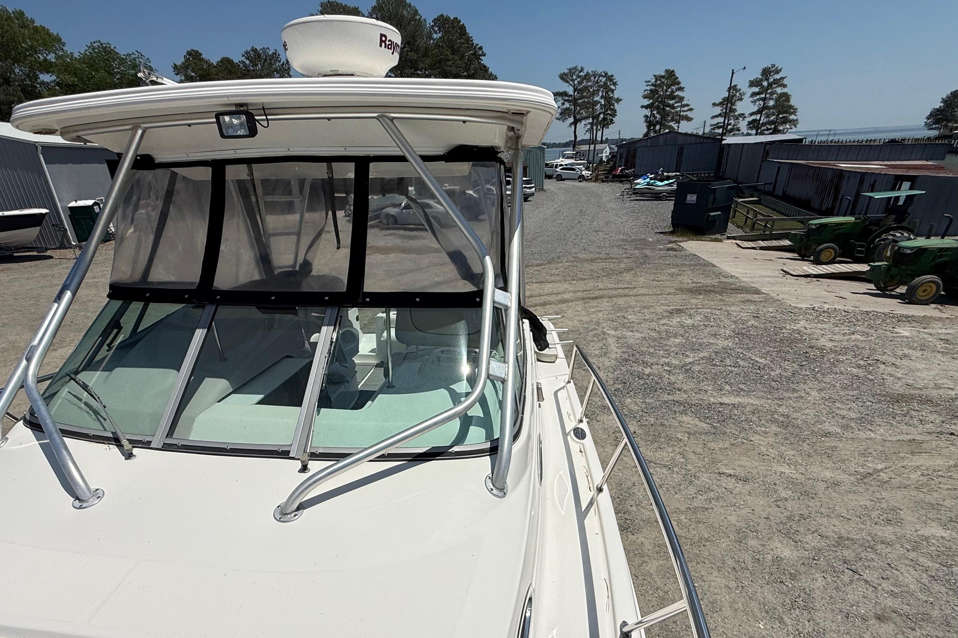 2007 Robalo R305 Walkaround boat docked in a marina with clear skies.