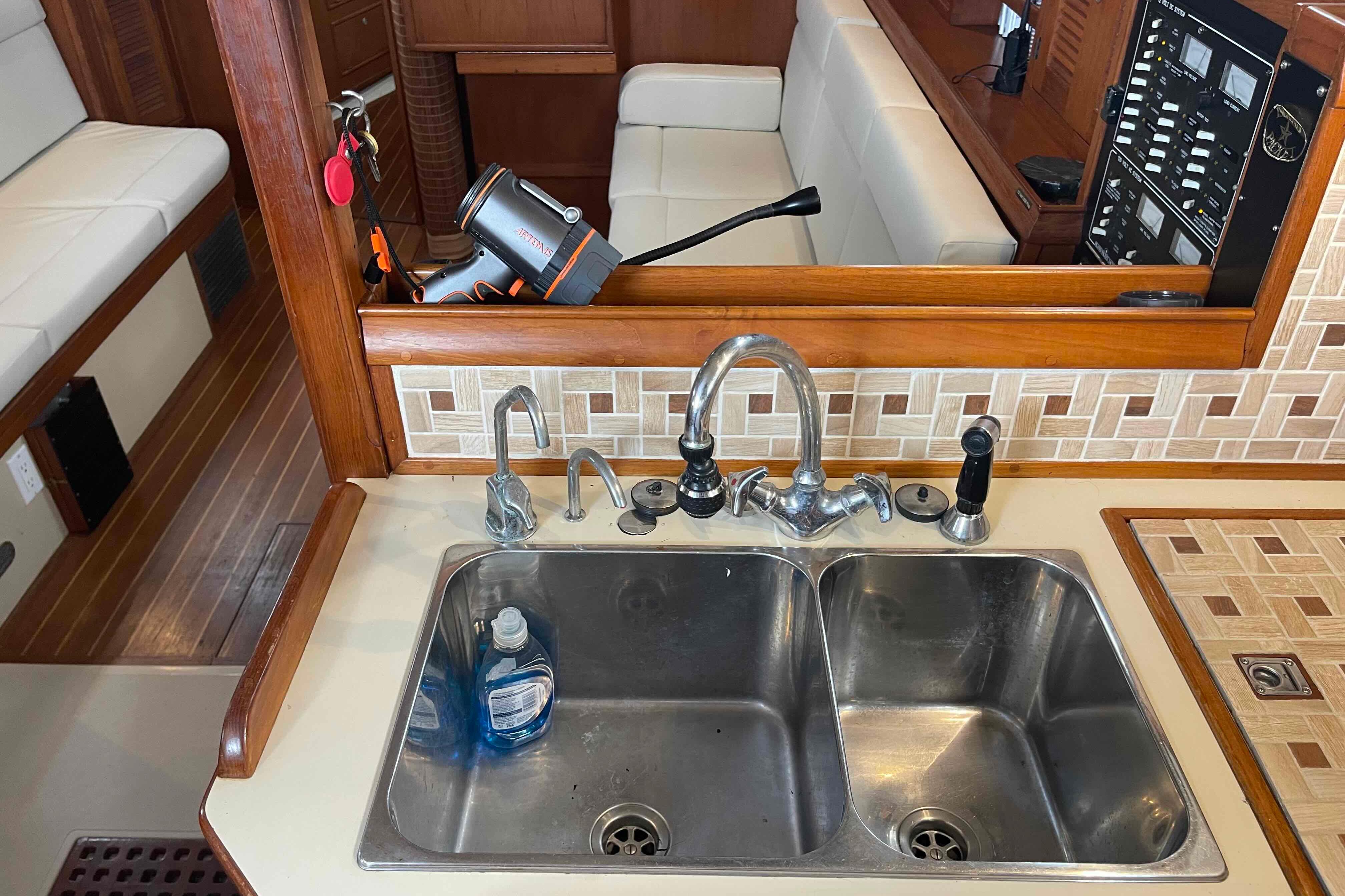 Galley sink area on a 1998 Island Packet 40 sailboat, featuring dual basins and wooden accents.