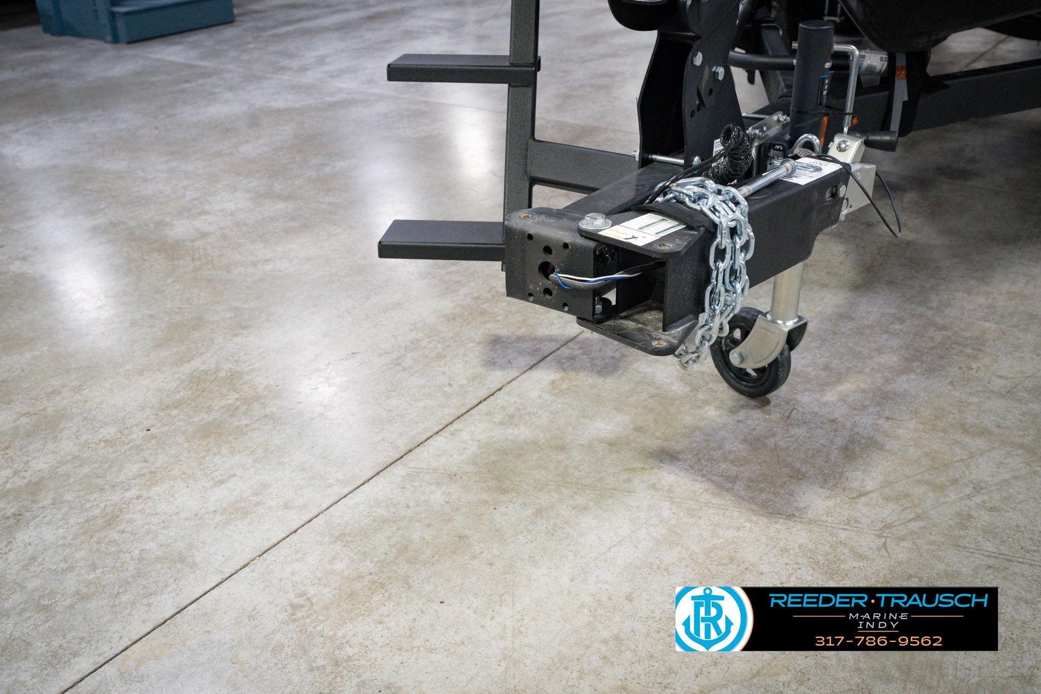 Trailer hitch of 2026 Lund 1875 Impact XS SS with chain on concrete floor.