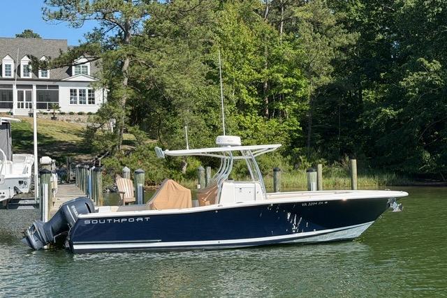 2014 Southport 29 FE boat docked on a serene lake with lush greenery.