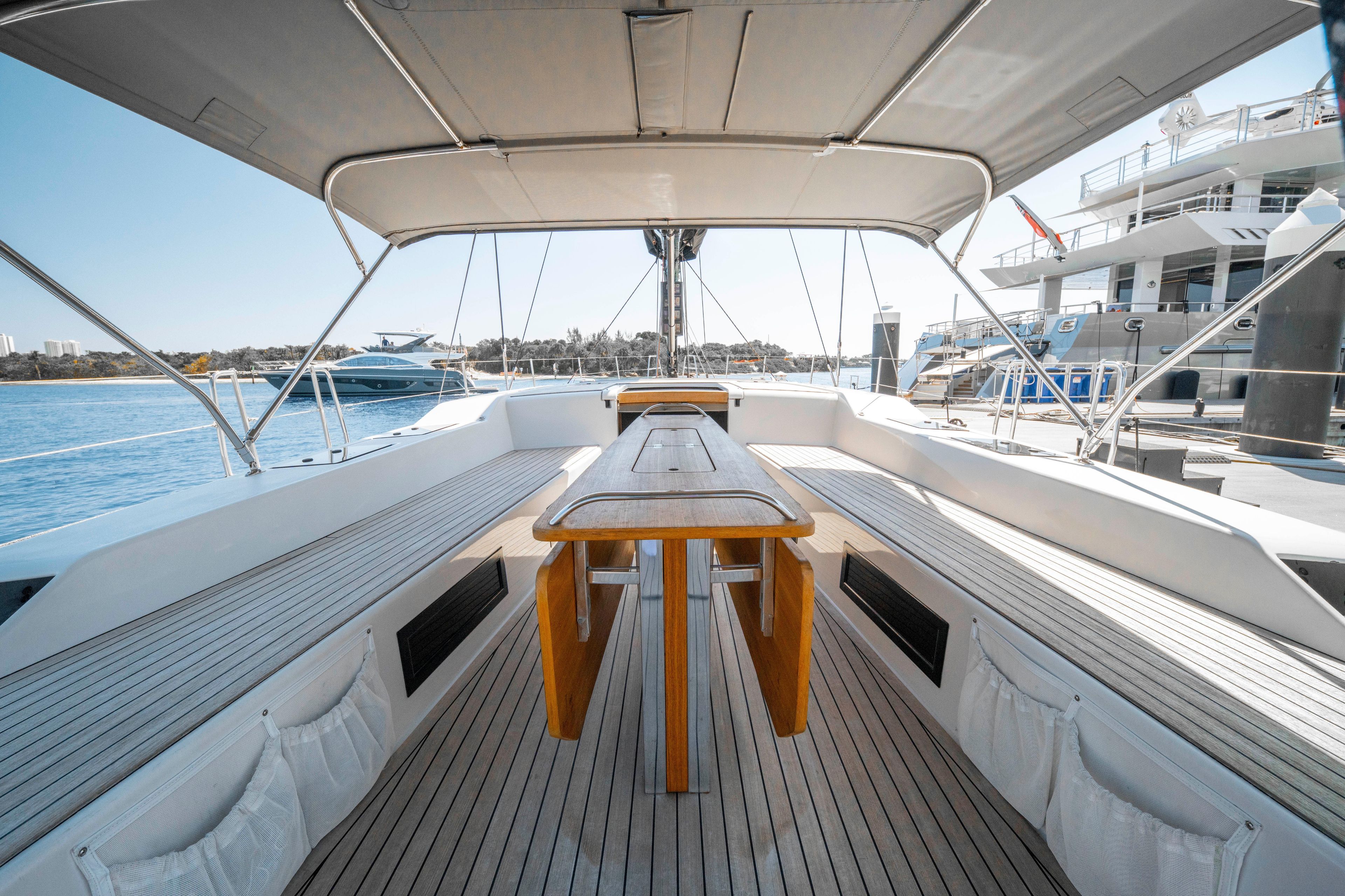 Spacious deck of 2016 Grand Soleil 58 yacht, featuring elegant wooden table and seating.