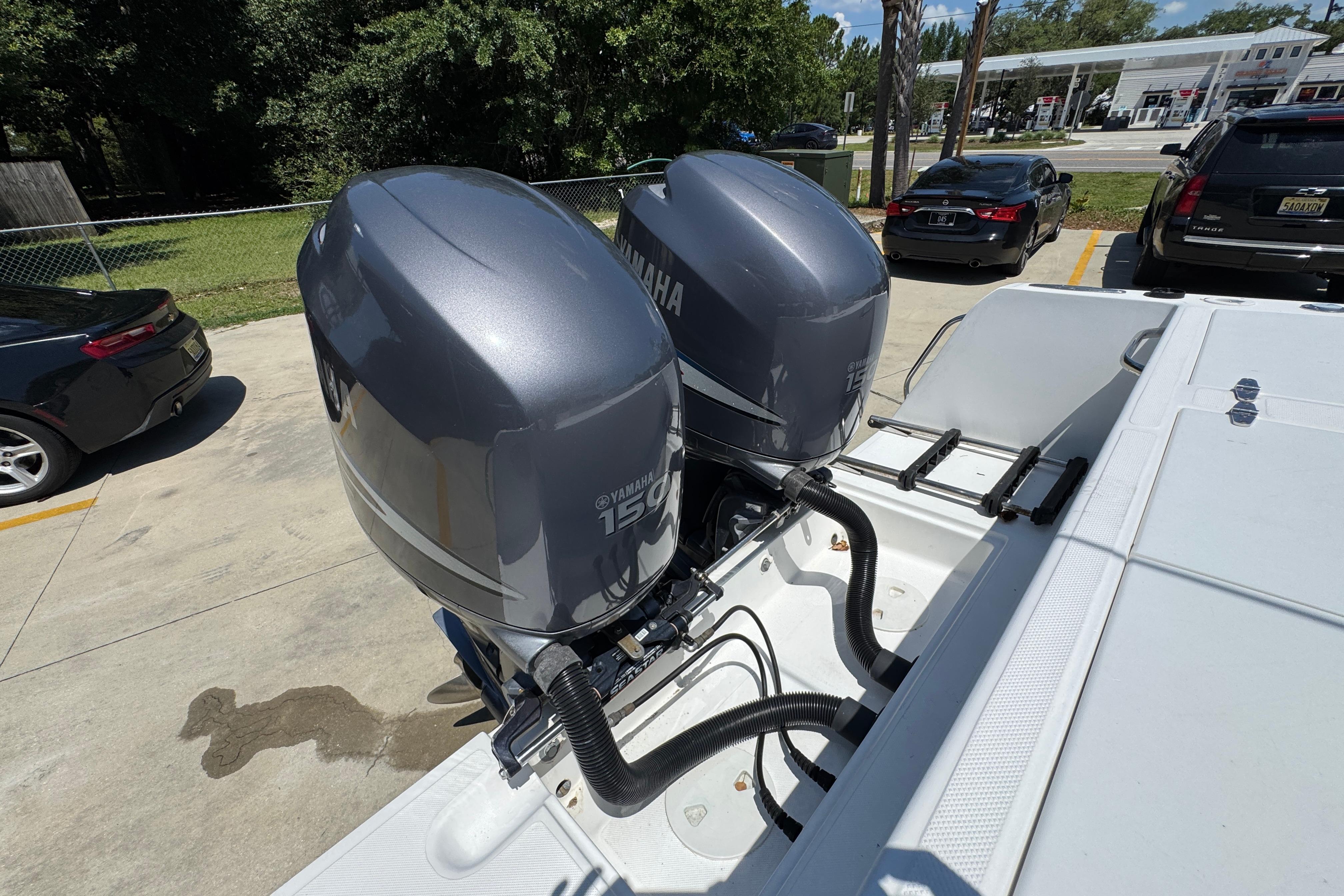 Twin Yamaha 150 engines on a 2000 Stamas 250 Tarpon boat in a parking lot.