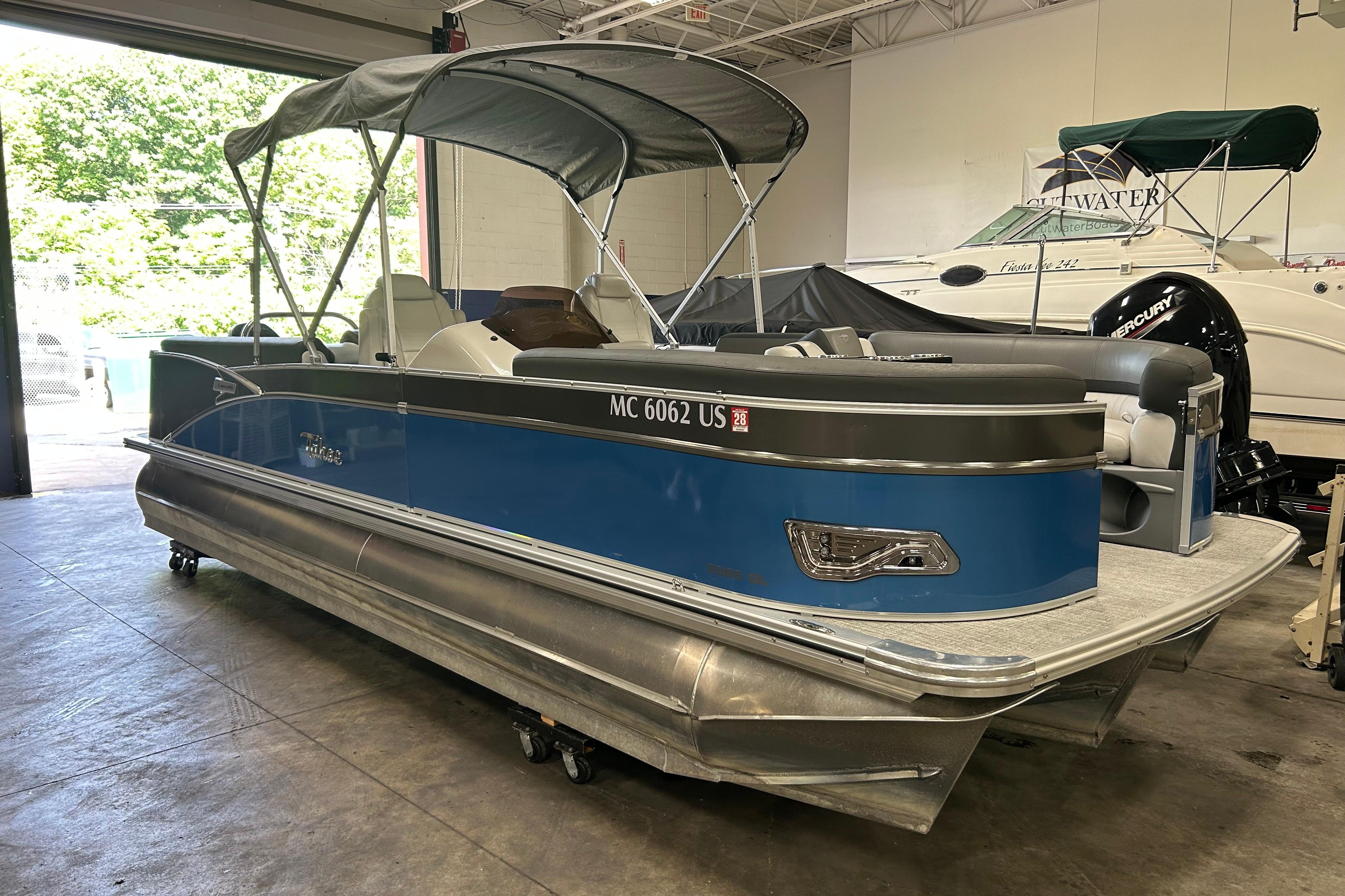2022 Tahoe Pontoon Cascade Quad Lounger in a showroom, featuring a sleek blue design.