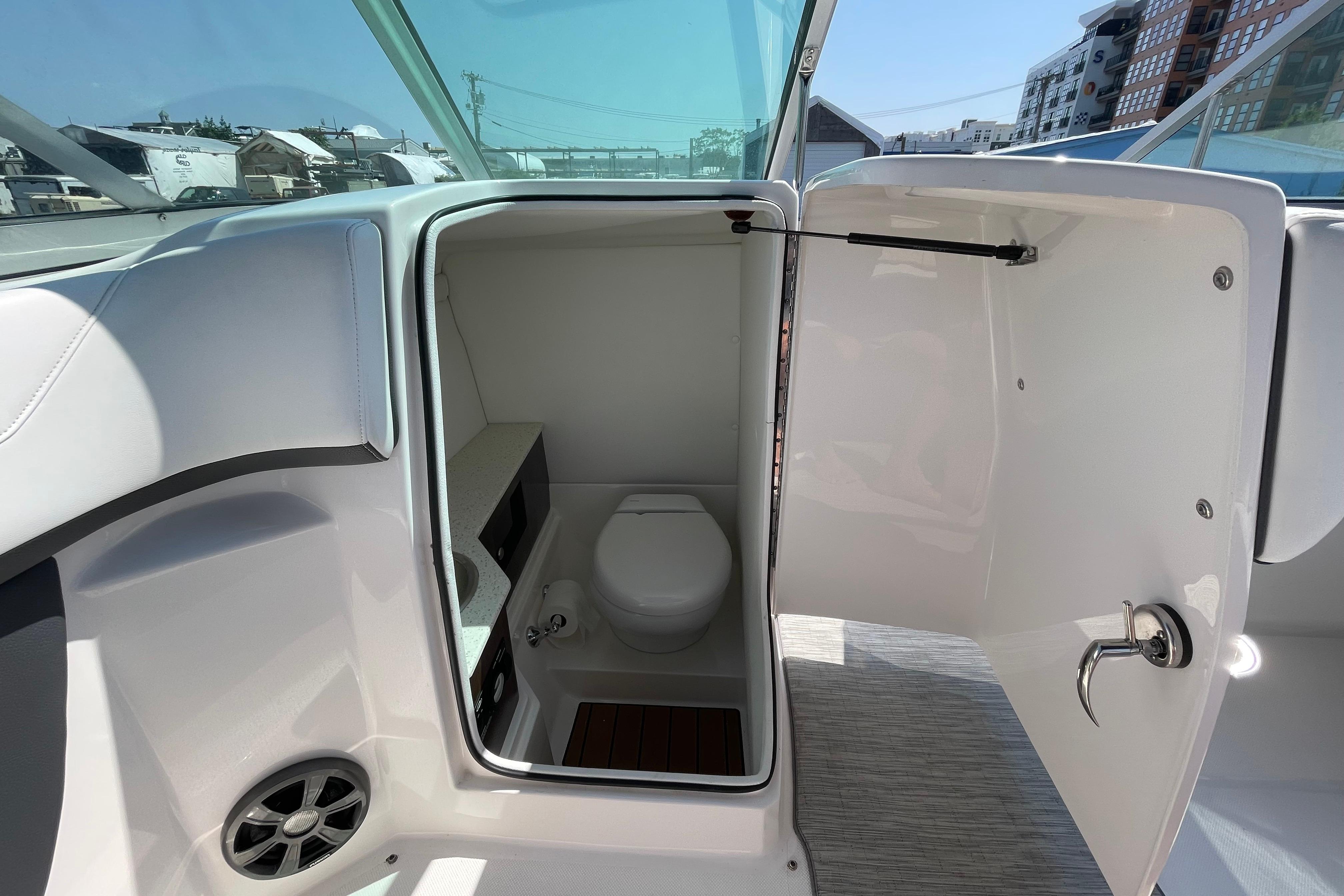 2018 Regal 26 OBX boat interior with open bathroom door, showcasing toilet and sink.