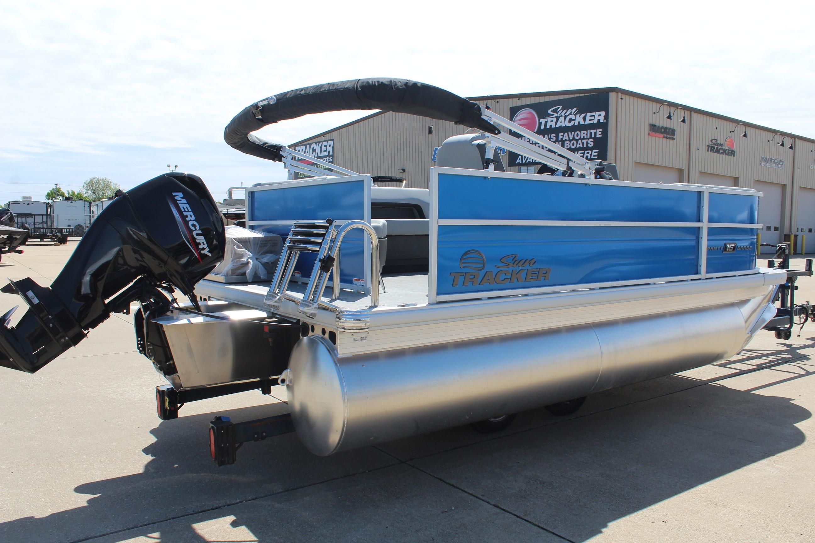 2026 Sun Tracker Party Barge 16 DLX pontoon boat with Mercury engine, parked outdoors.