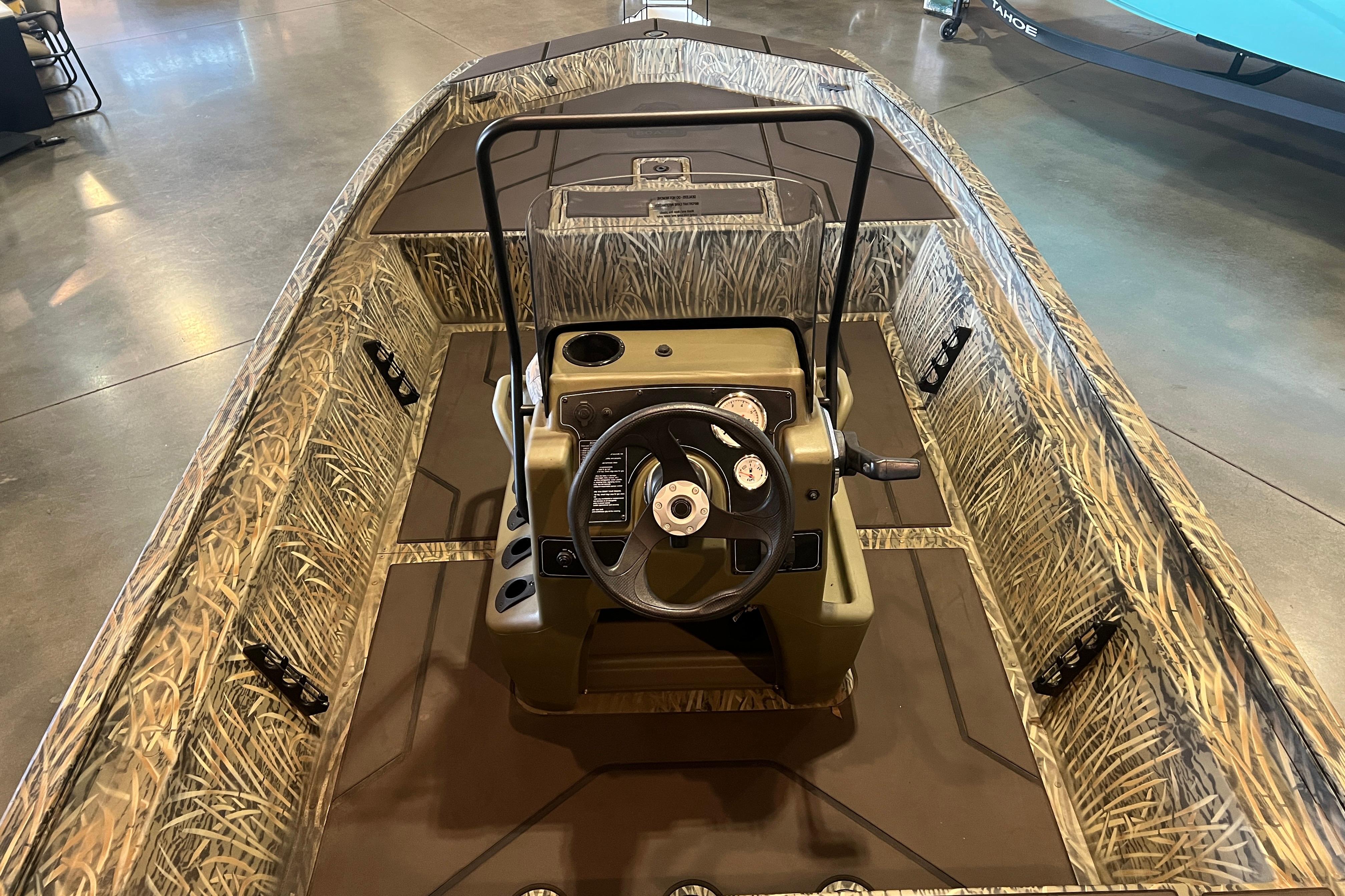 2026 Tracker Grizzly 1860 CC boat with camouflage interior and steering console.