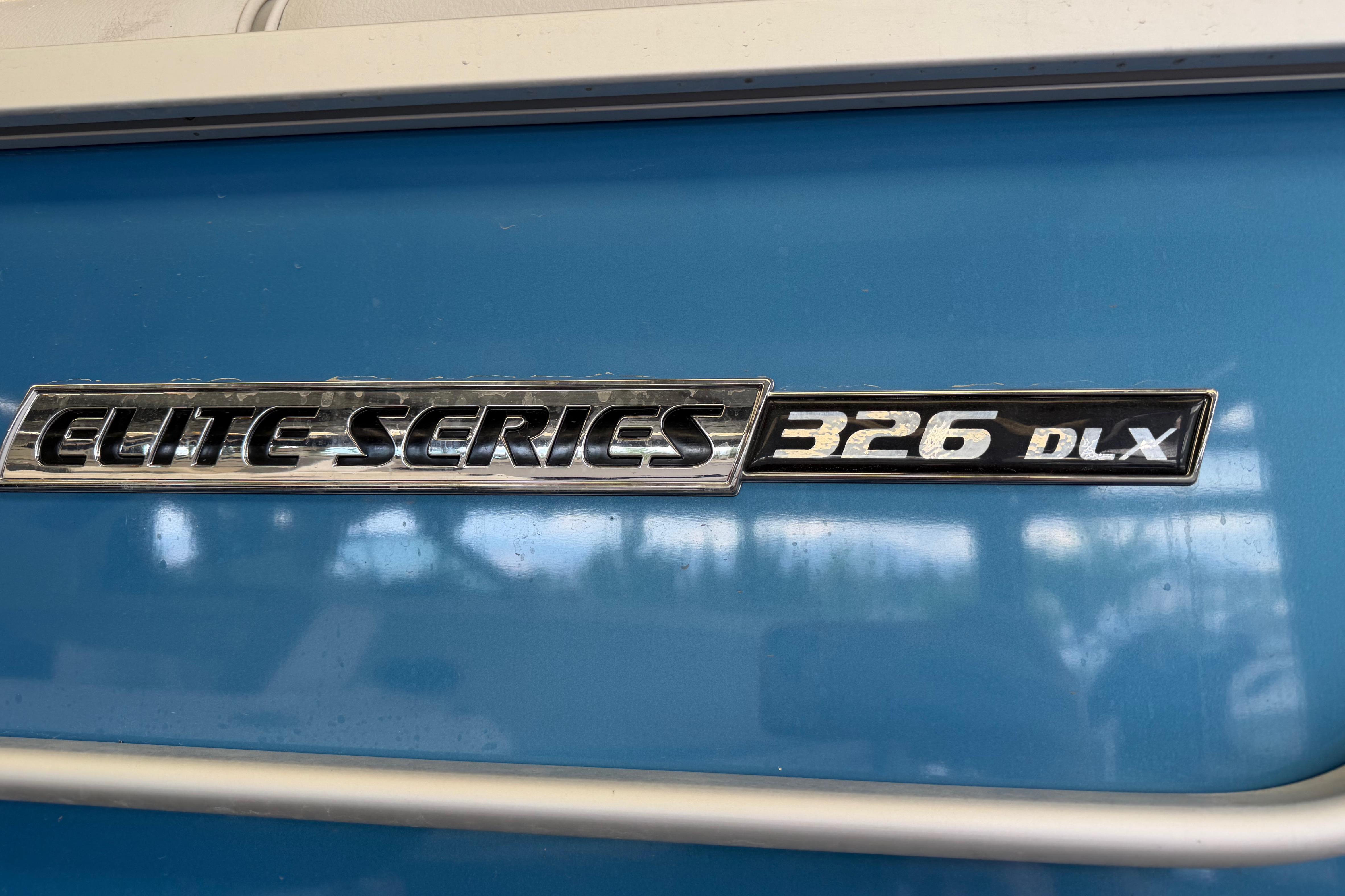 2024 SunCatcher Elite 326 SS DLX emblem on blue background.