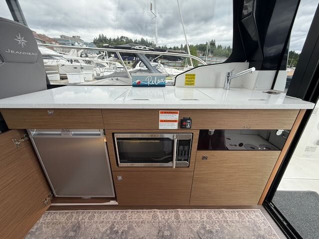 Interior of the Jeanneau NC 1095 featuring a modern kitchen and harbor view.
