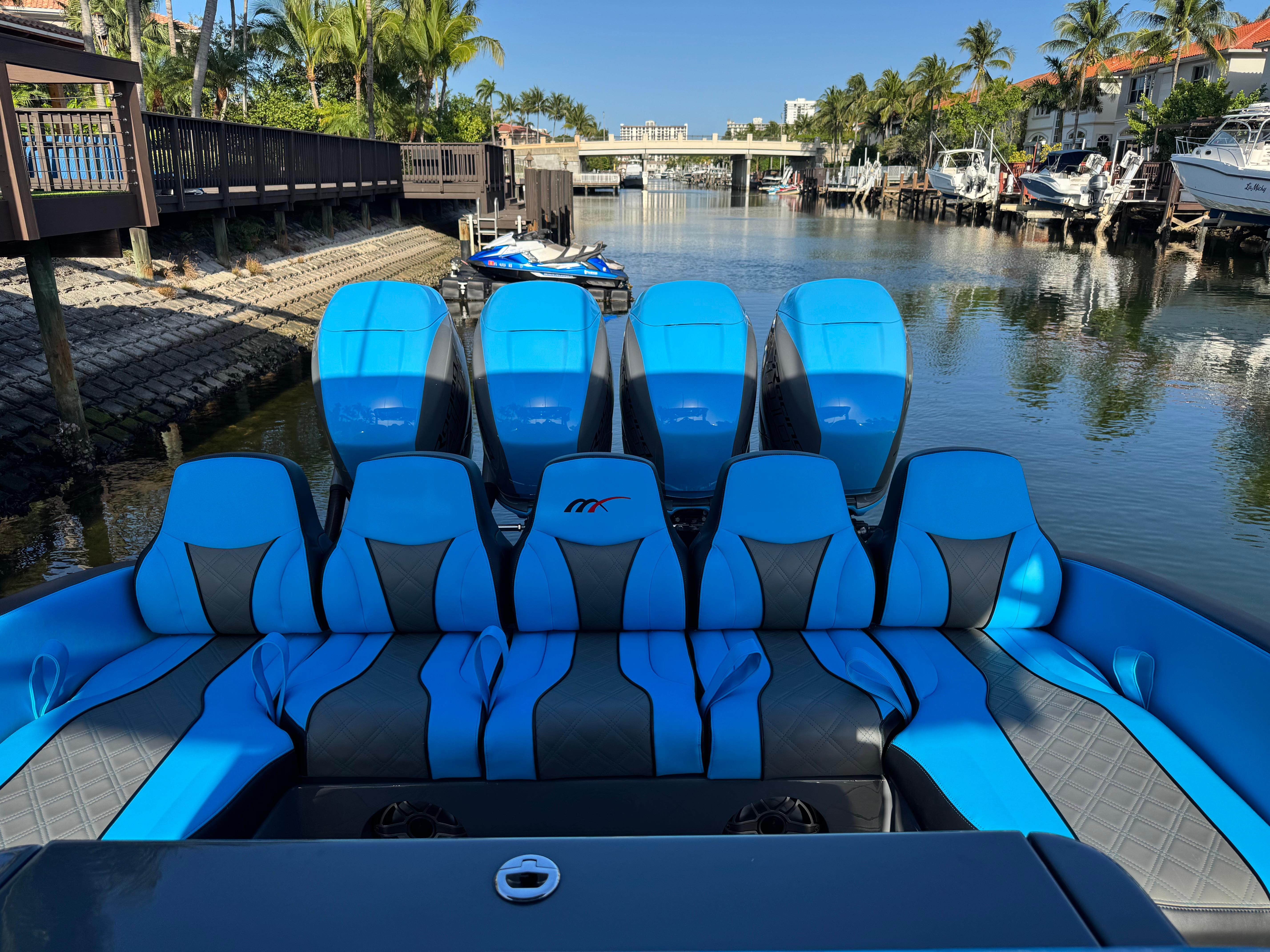 2021 Midnight Express 37 Open boat with blue seating and multiple engines docked in a canal.