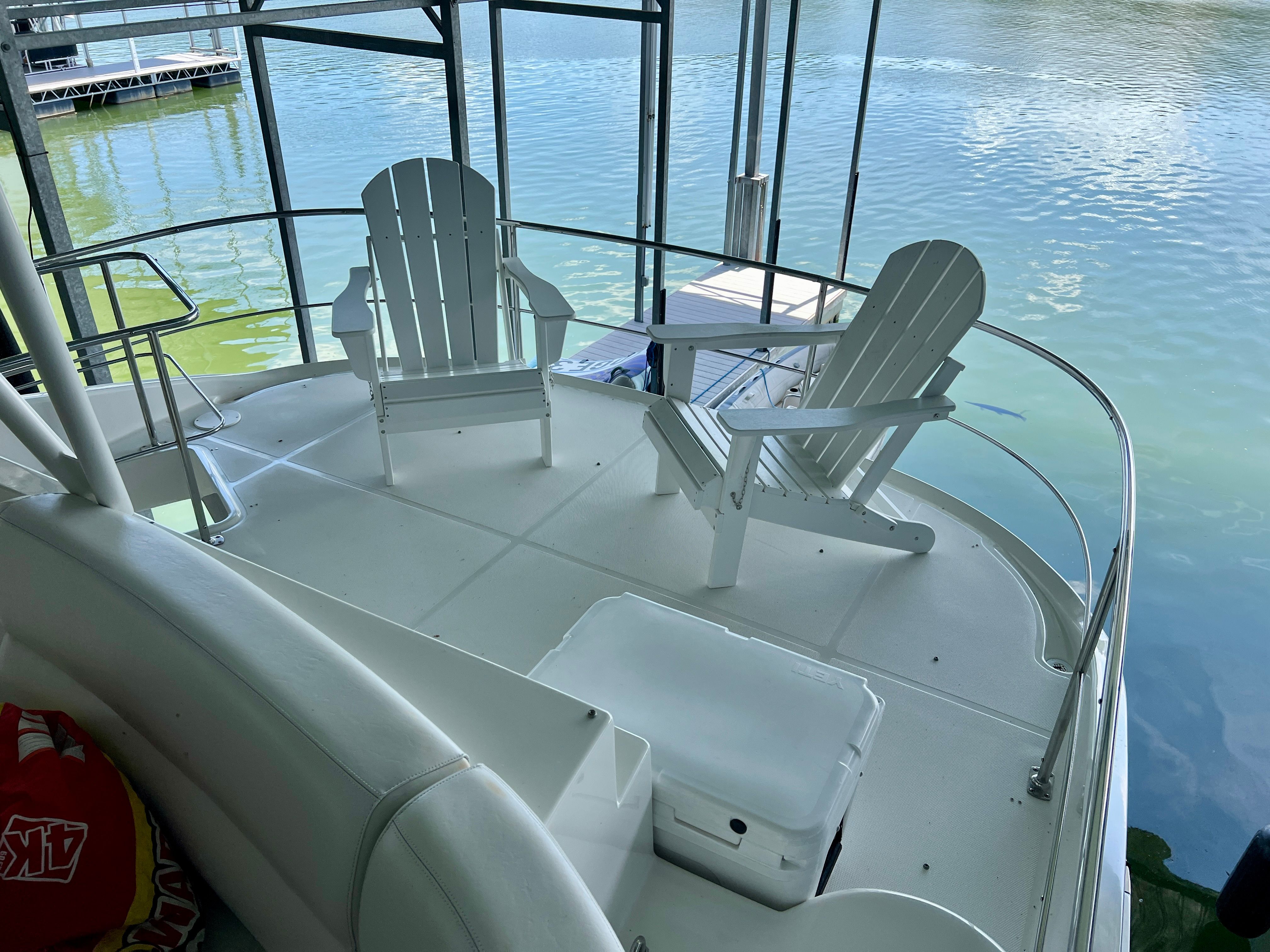 Deck of a 2005 Carver 560 Voyager Sky with chairs by the water.