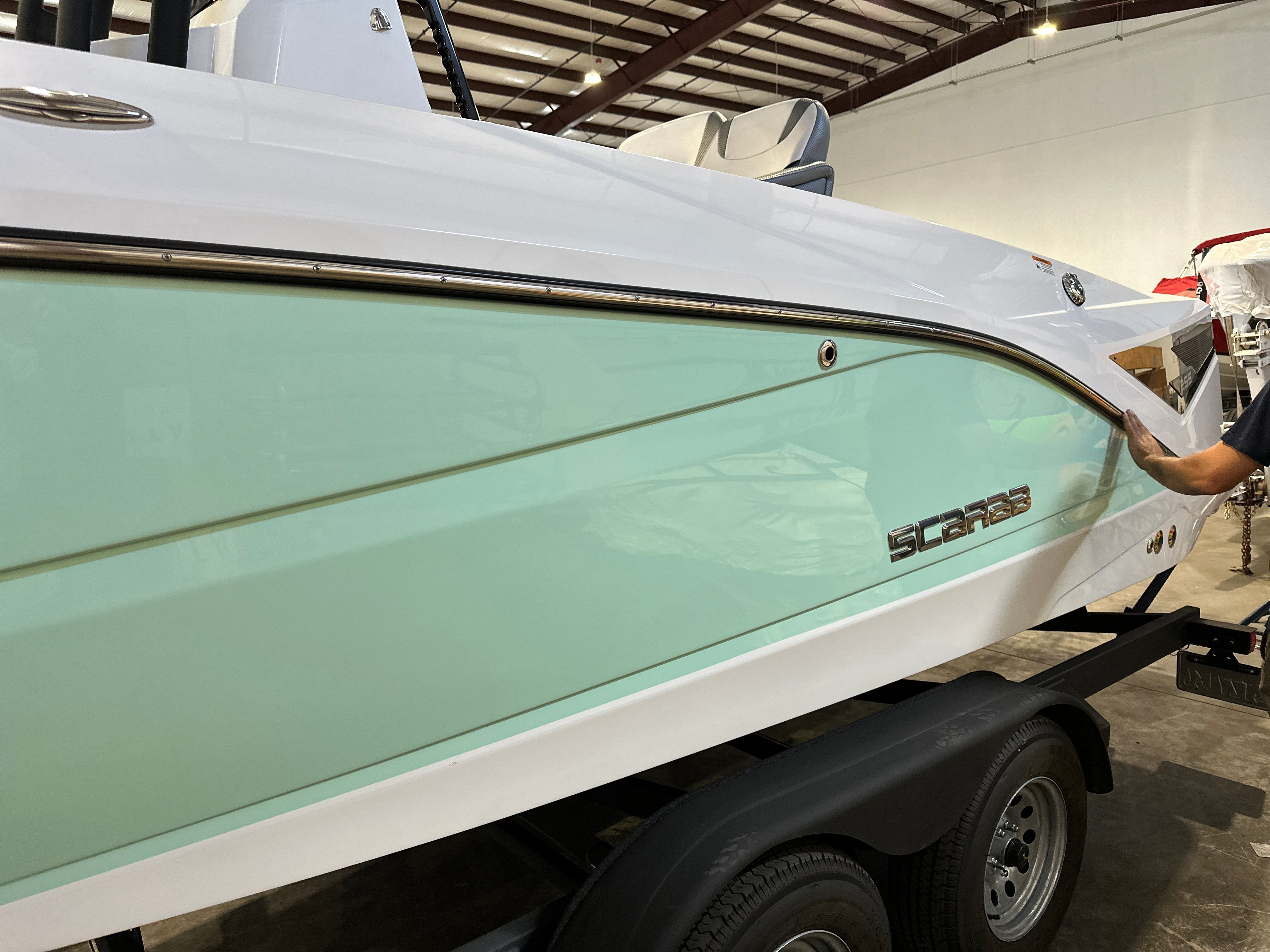 A 2021 Scarab 255 Open ID boat on a trailer inside a warehouse.
