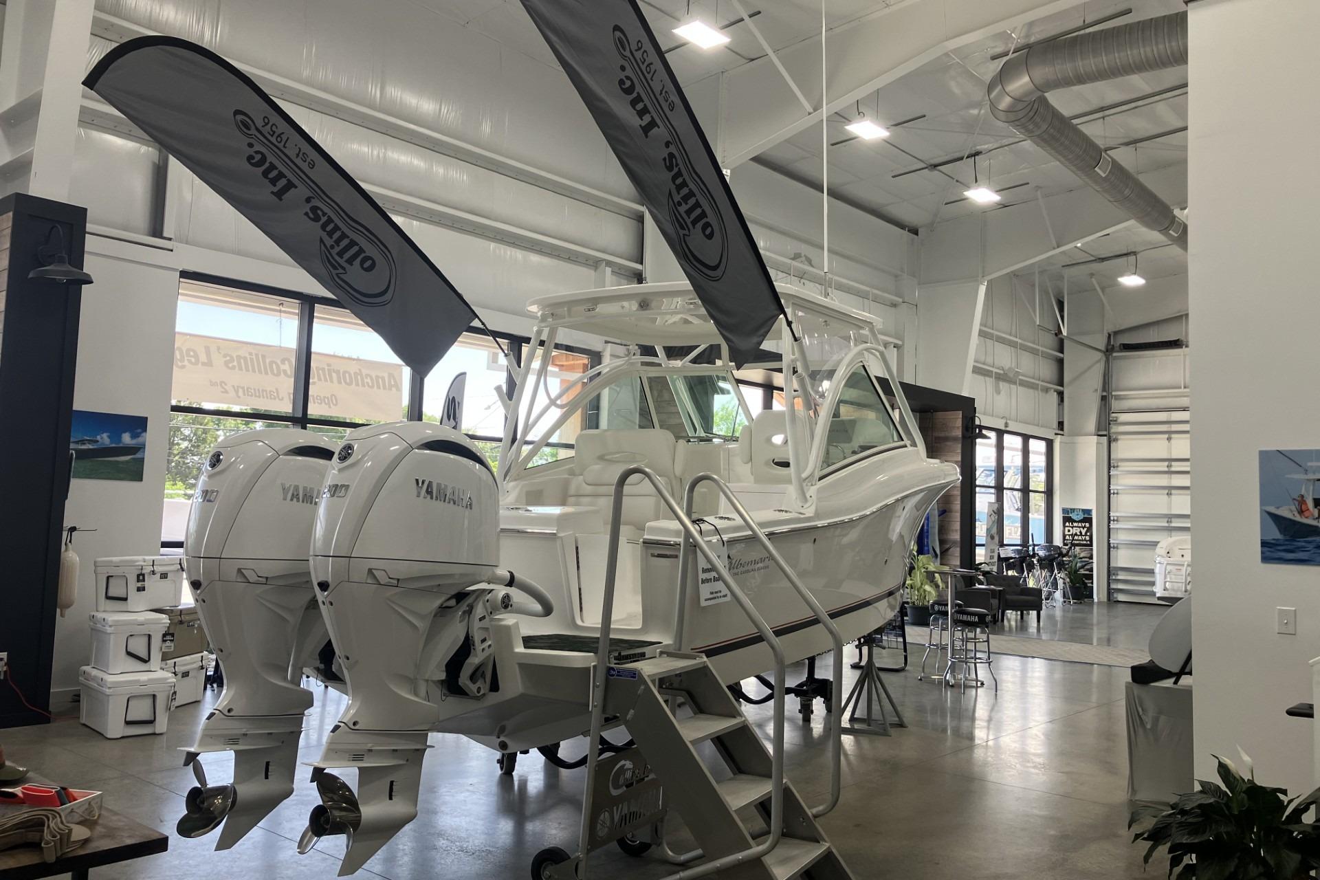 2026 Albemarle 27 Dual Console boat displayed indoors with Yamaha engines.