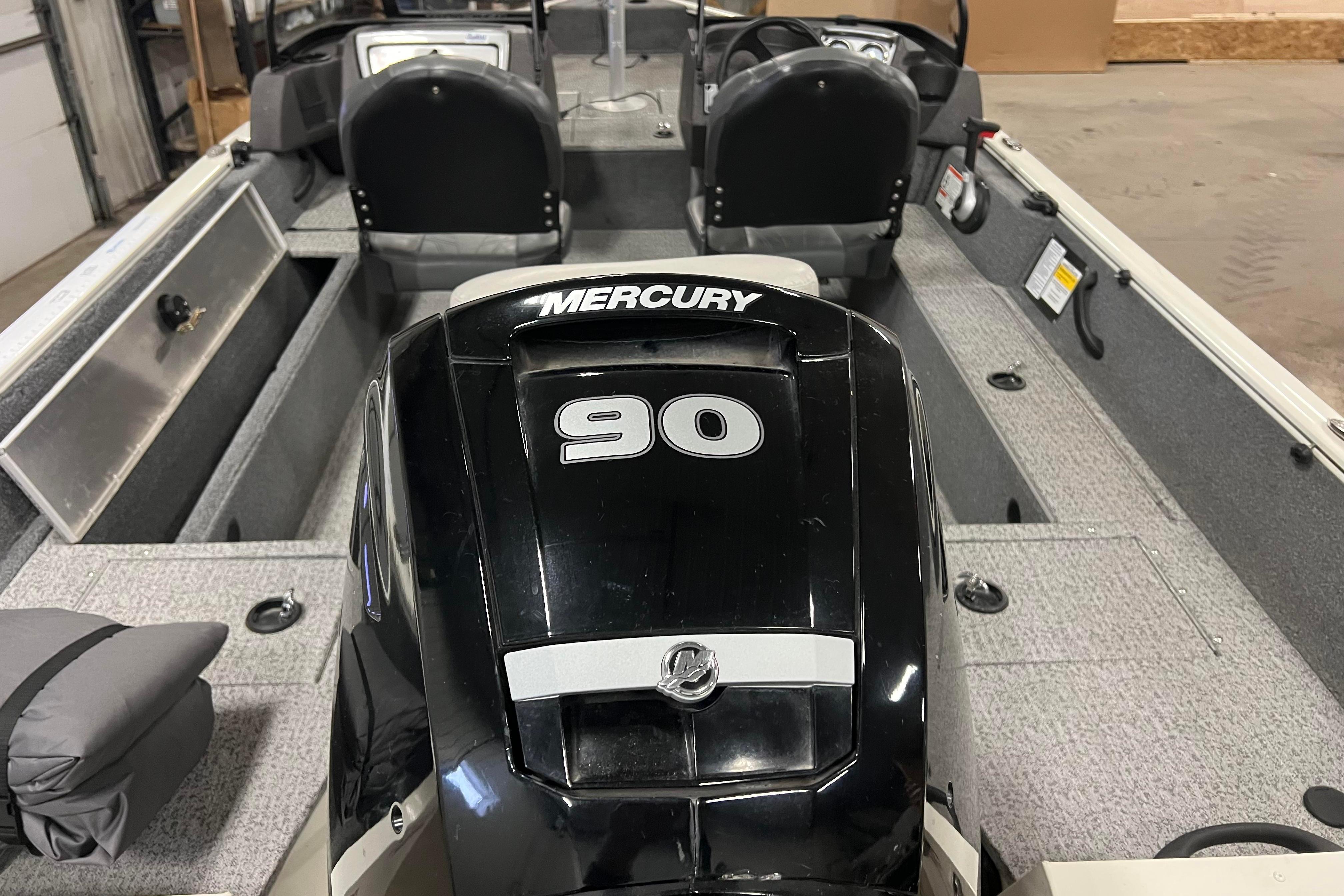 2022 Tracker Pro Guide V-16 WT boat with Mercury 90 engine in a garage.