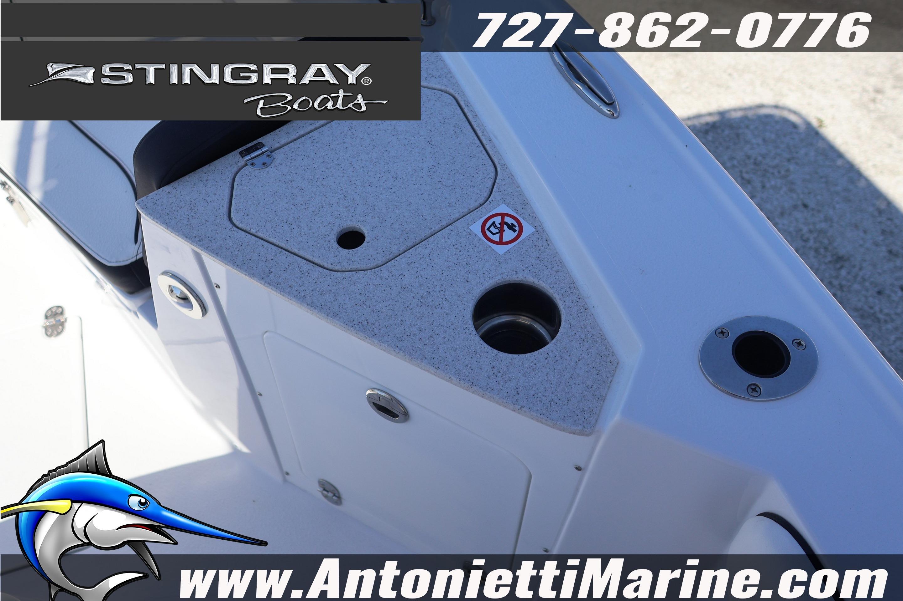 2026 Stingray 216 CC boat deck with storage compartments and fishing rod holders.
