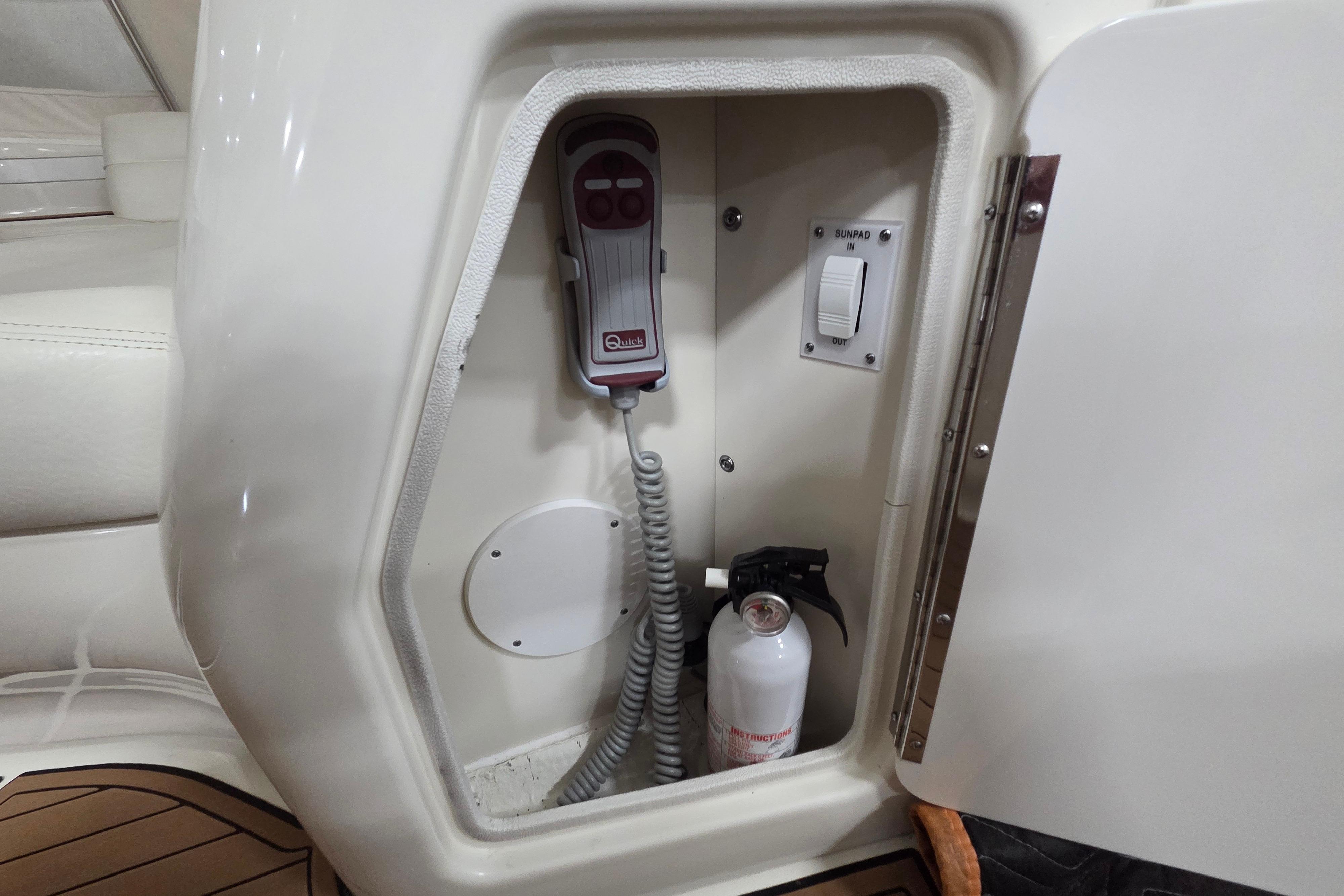 Storage compartment on a 2000 Sea Ray Sundancer 540 yacht with control panel and fire extinguisher.