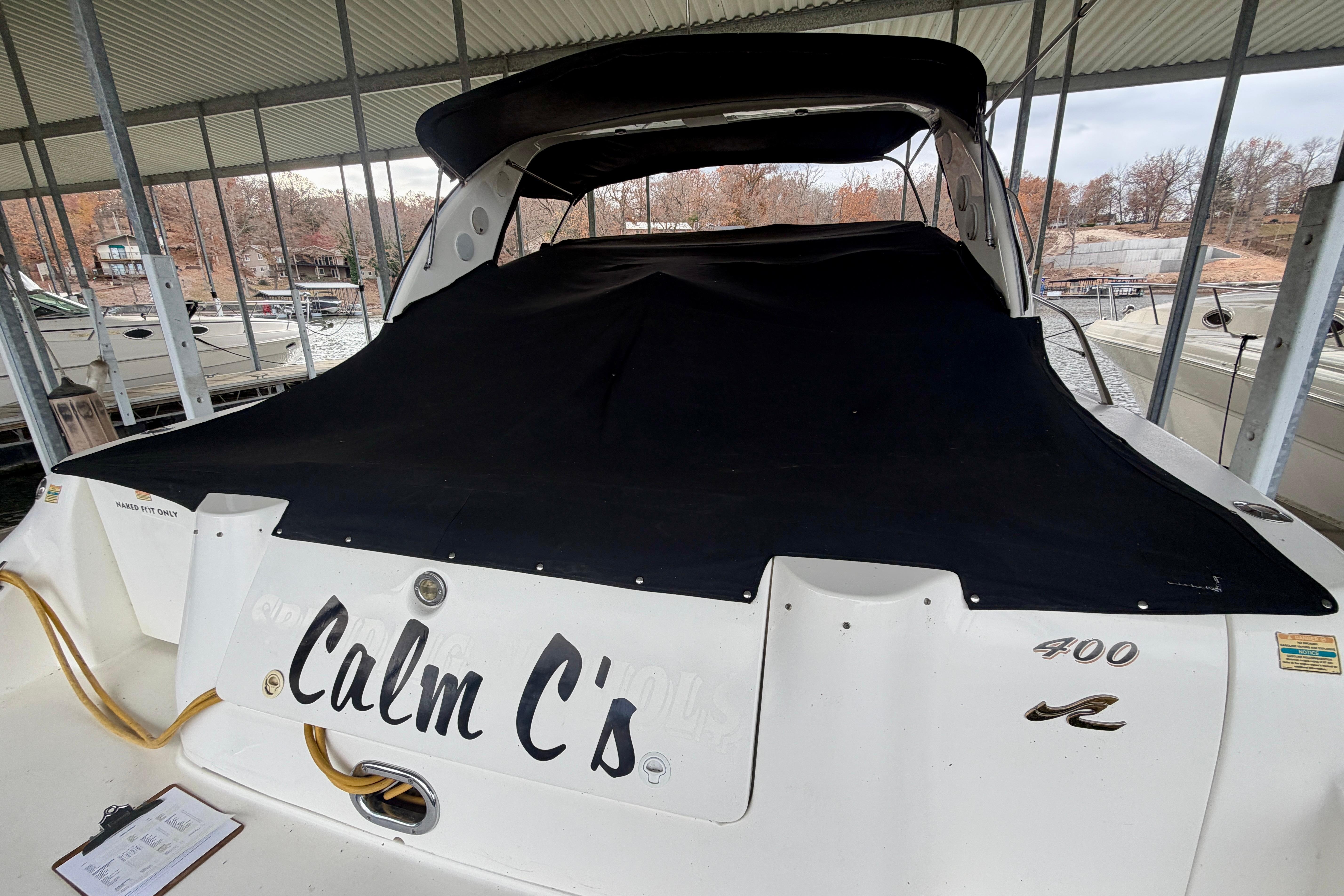1999 Sea Ray 400 Sundancer yacht, named "Calm C's," docked under a covered marina.