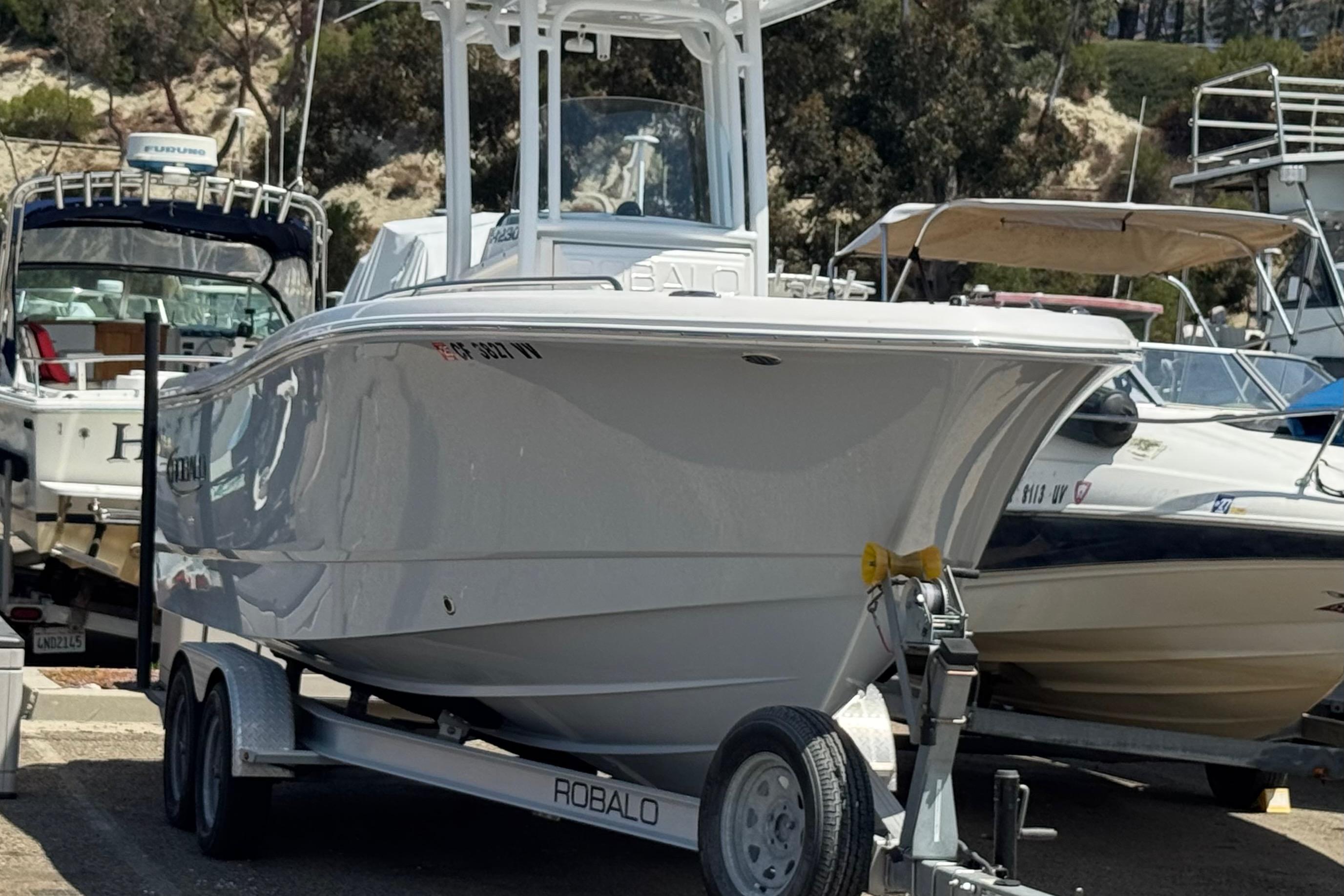 2022 Robalo R230 Center Console boat on trailer, parked among other boats.