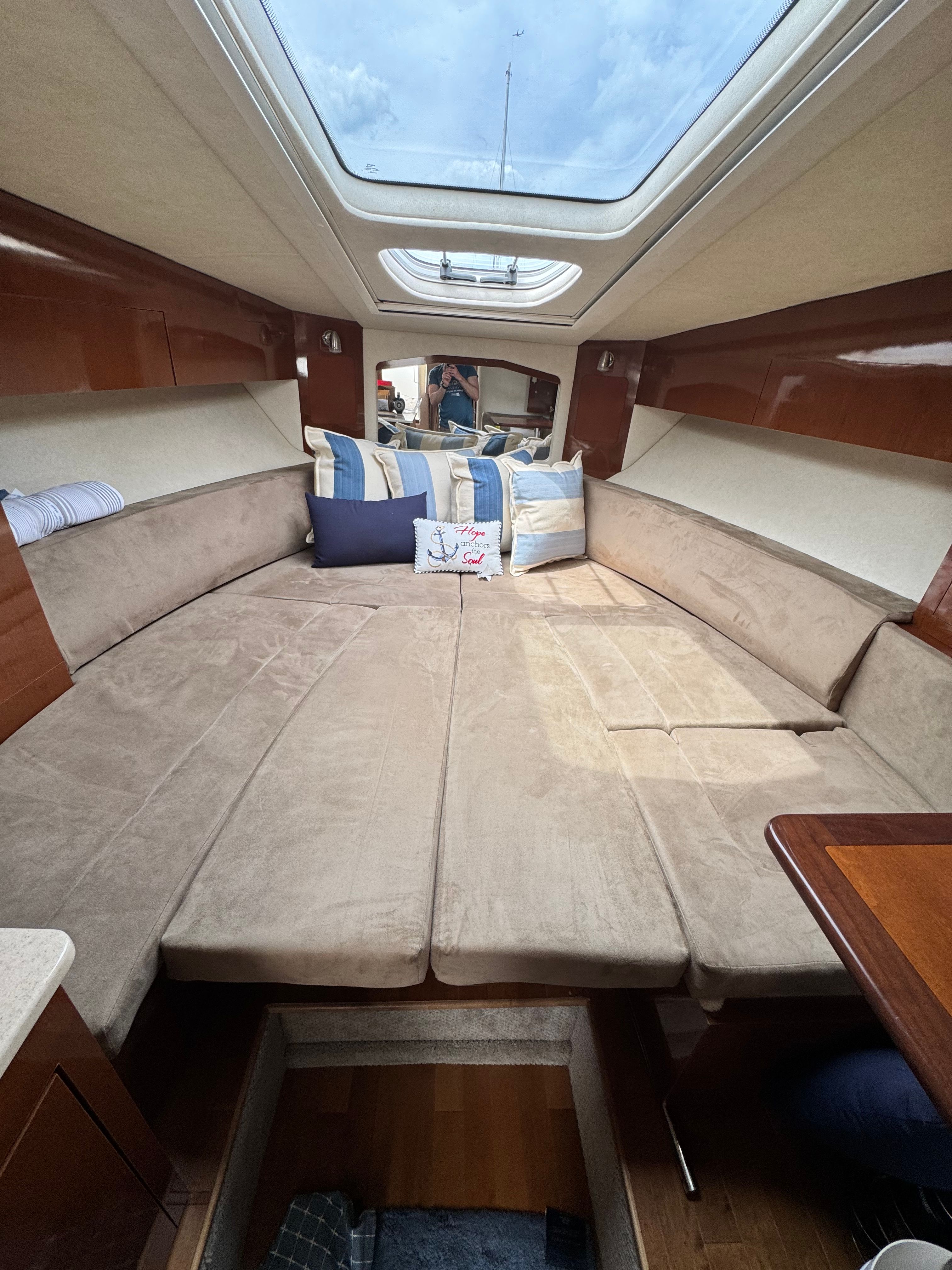 Interior of a Sea Ray Sundancer 310 with beige upholstery and skylights.