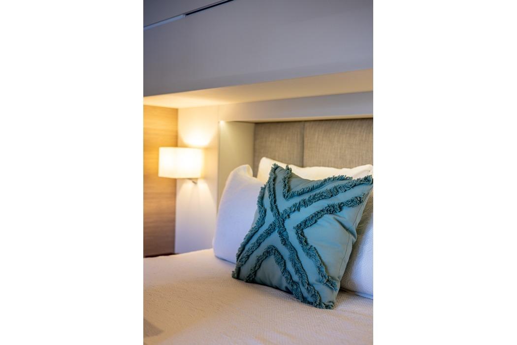 Luxurious bedroom interior of 2023 Fountaine Pajot Samana 59 yacht with decorative pillow.