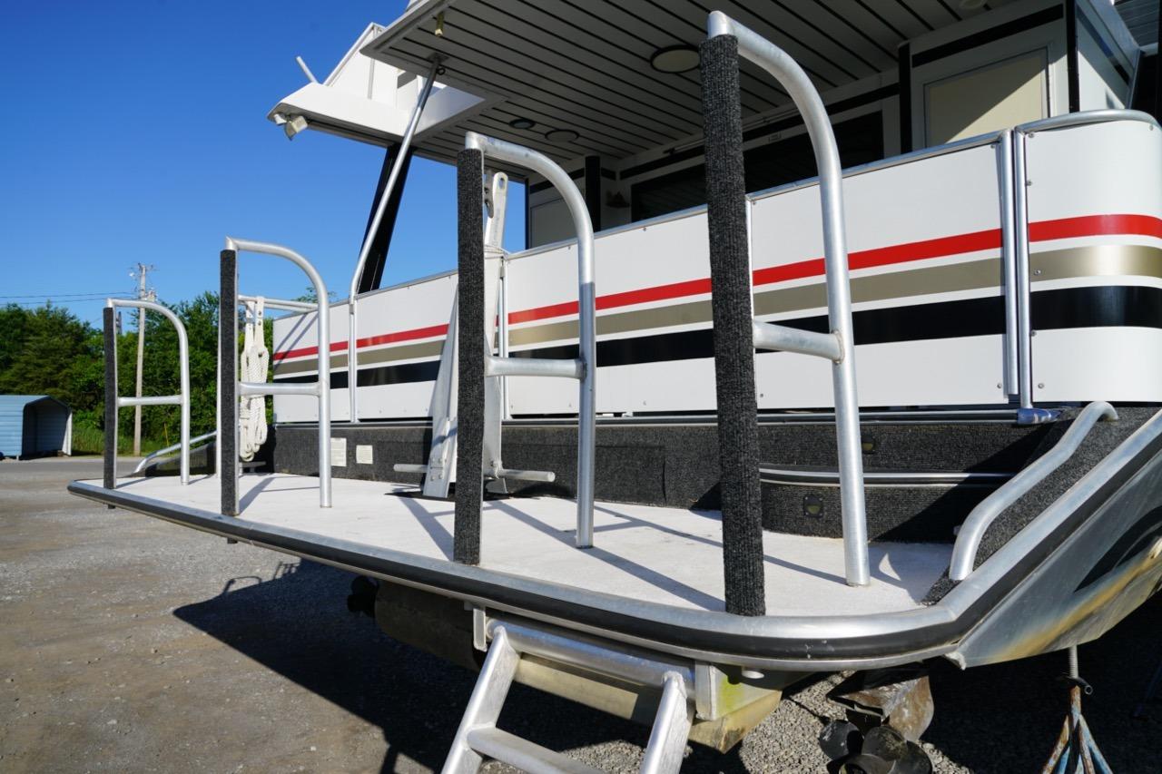 Stardust Cruisers 83'x17' houseboat, 2000 model, docked with railing and ladder.