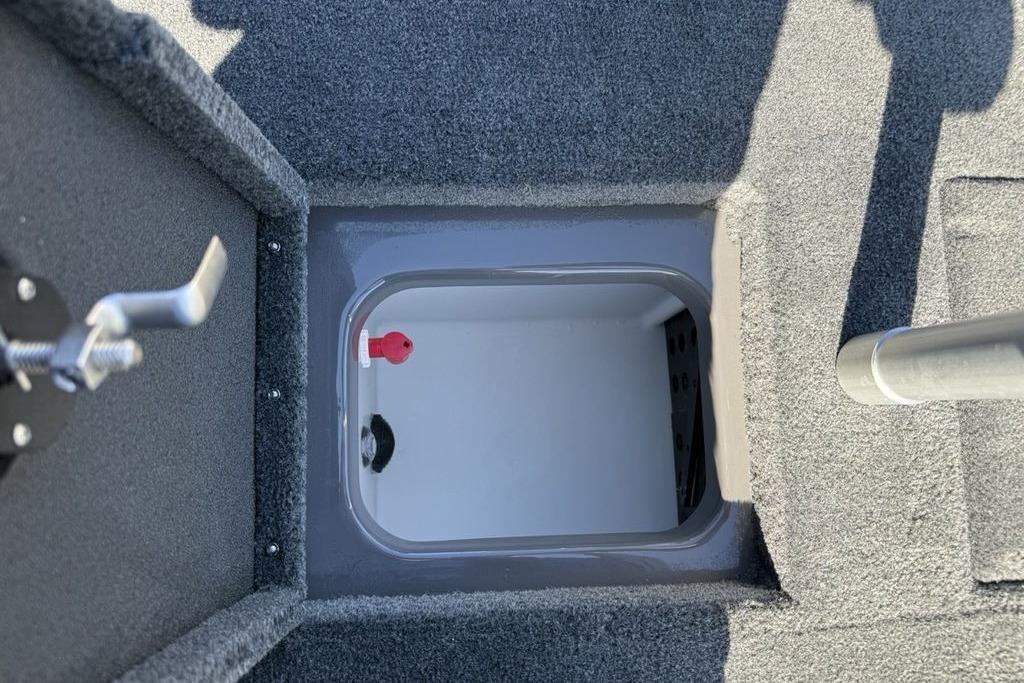 2026 Skeeter ZX150 boat storage compartment with gray carpeted interior and latch mechanism.