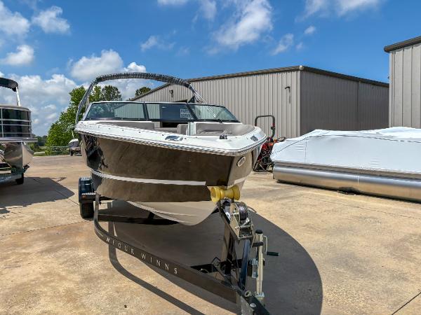 2023 Four Winns H1 boat on trailer, parked outdoors under a clear blue sky.