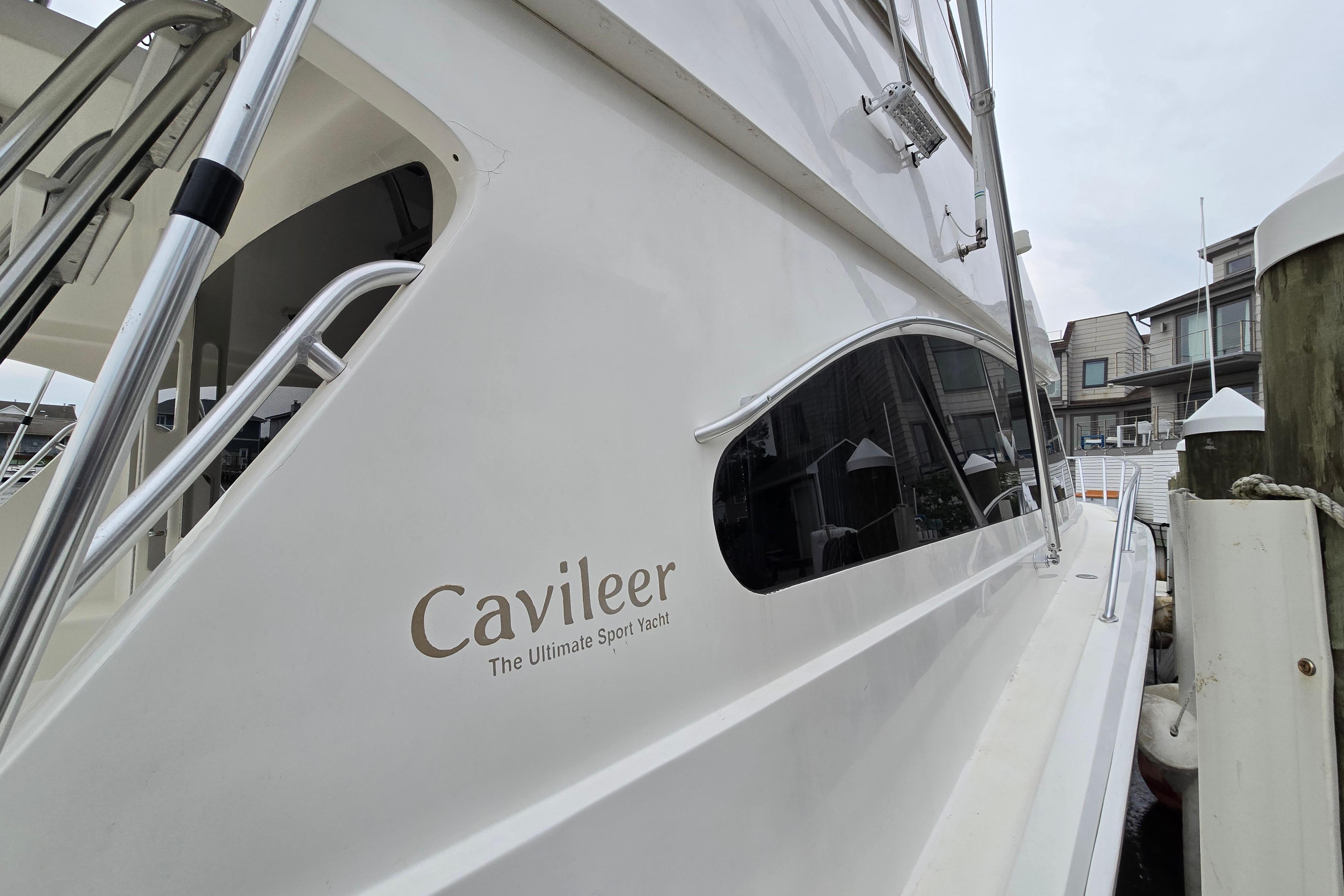 2001 Cavileer 53 Convertible yacht docked, showcasing sleek design and branding.