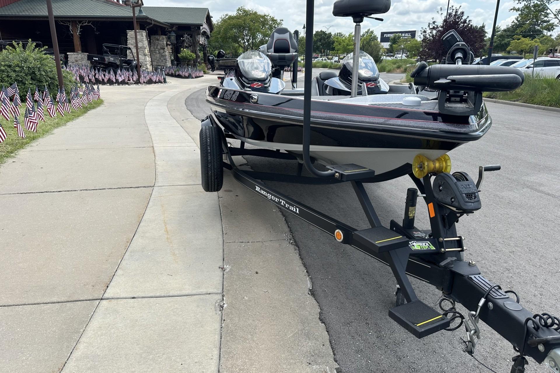 2018 Ranger Z518 boat on trailer, parked on roadside near American flags.