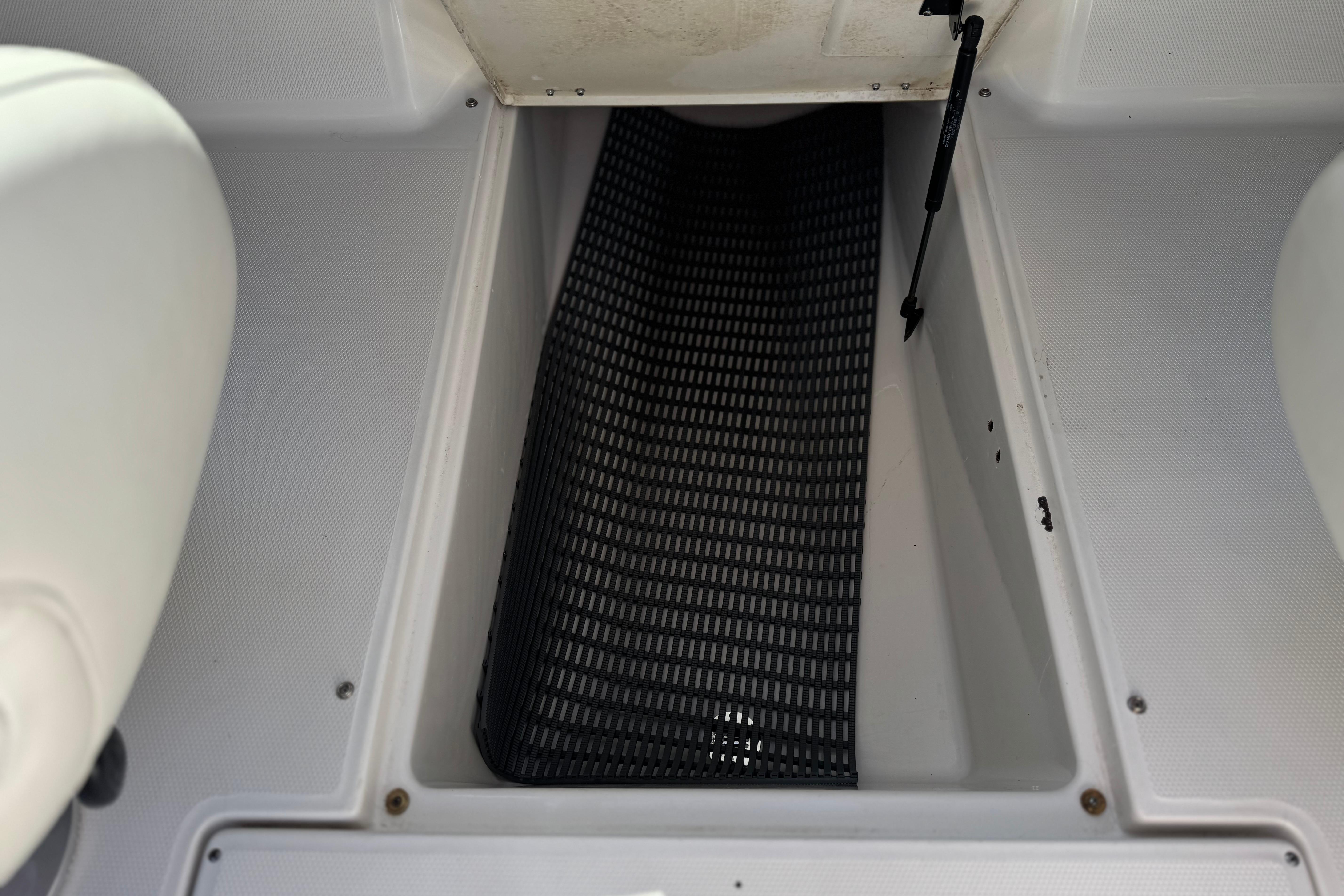 Storage compartment of a 2002 Chaparral 186 SSi boat with black mat lining.