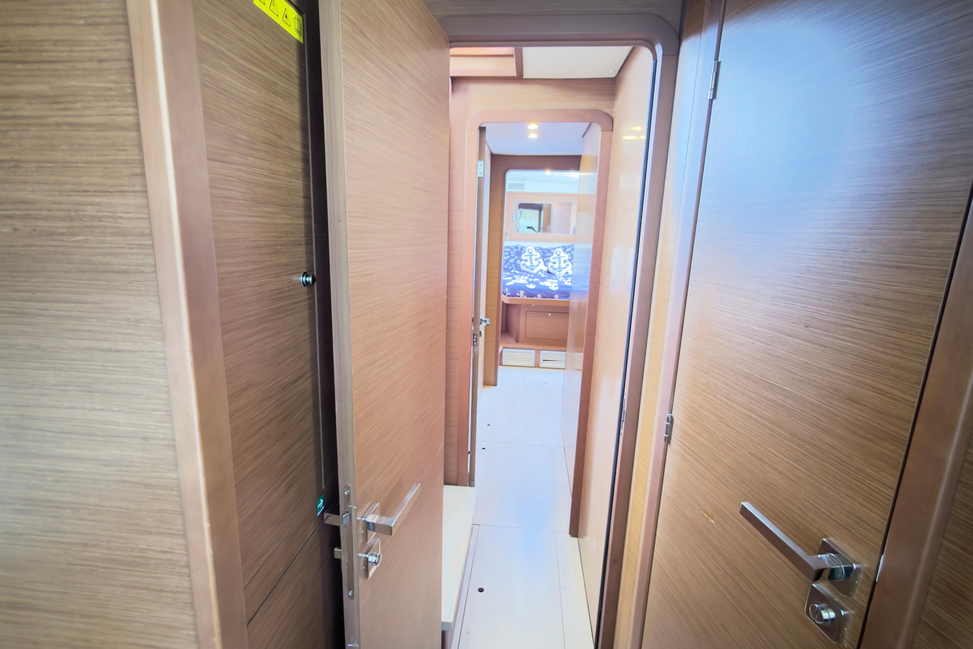 Interior hallway of 2019 Lagoon 450 catamaran with wooden doors and modern design.