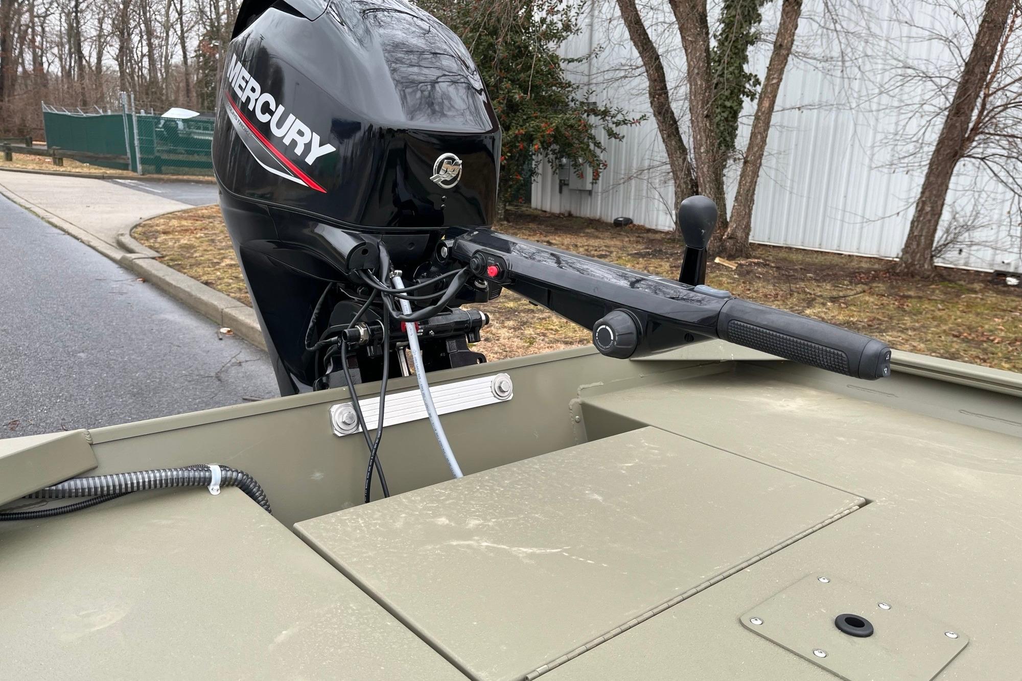 2026 Tracker Grizzly 1654 T Sportsman boat with Mercury outboard motor, parked outdoors.