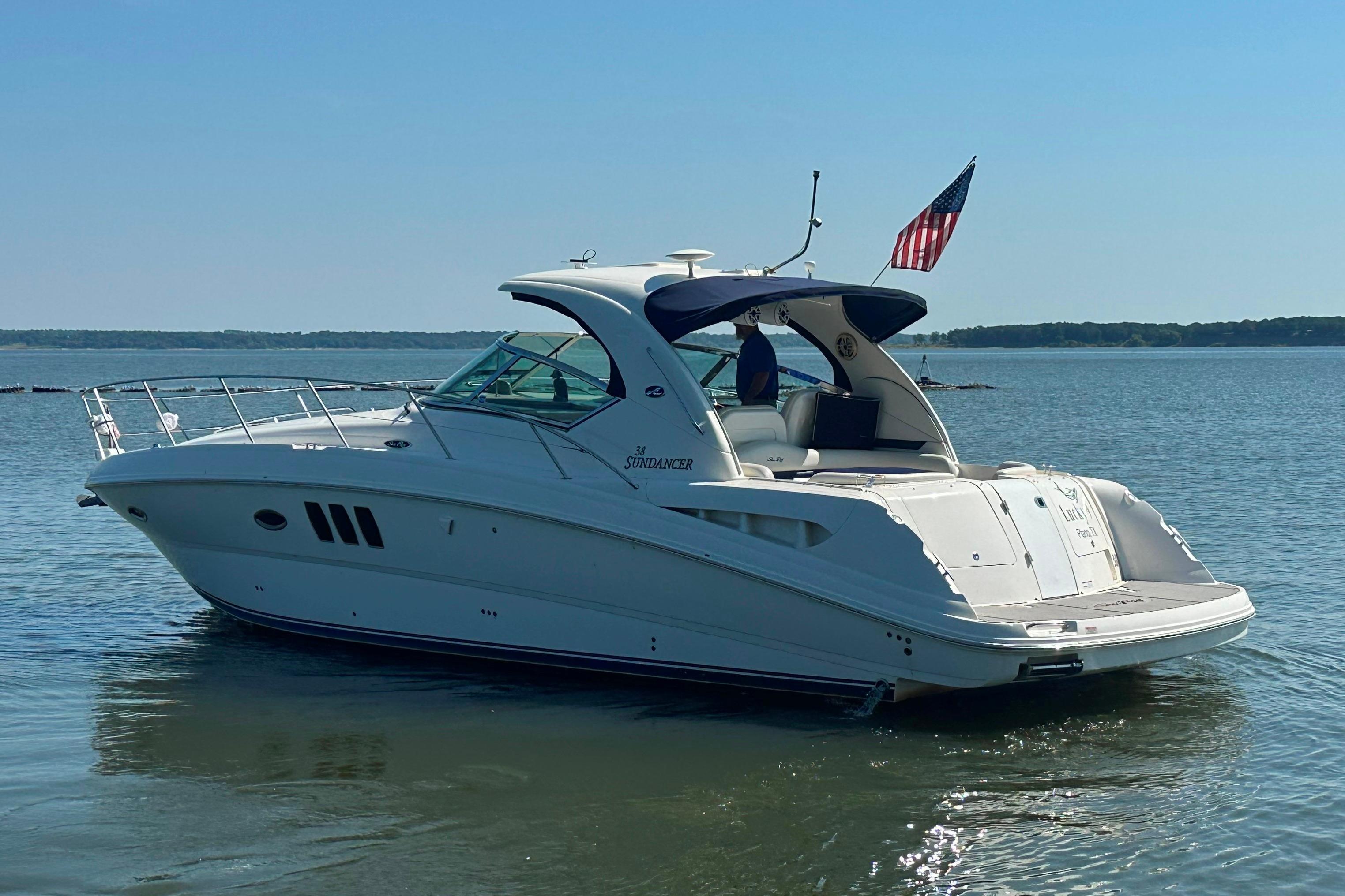 2007 Sea Ray 38 Sundancer yacht on calm water with American flag.
