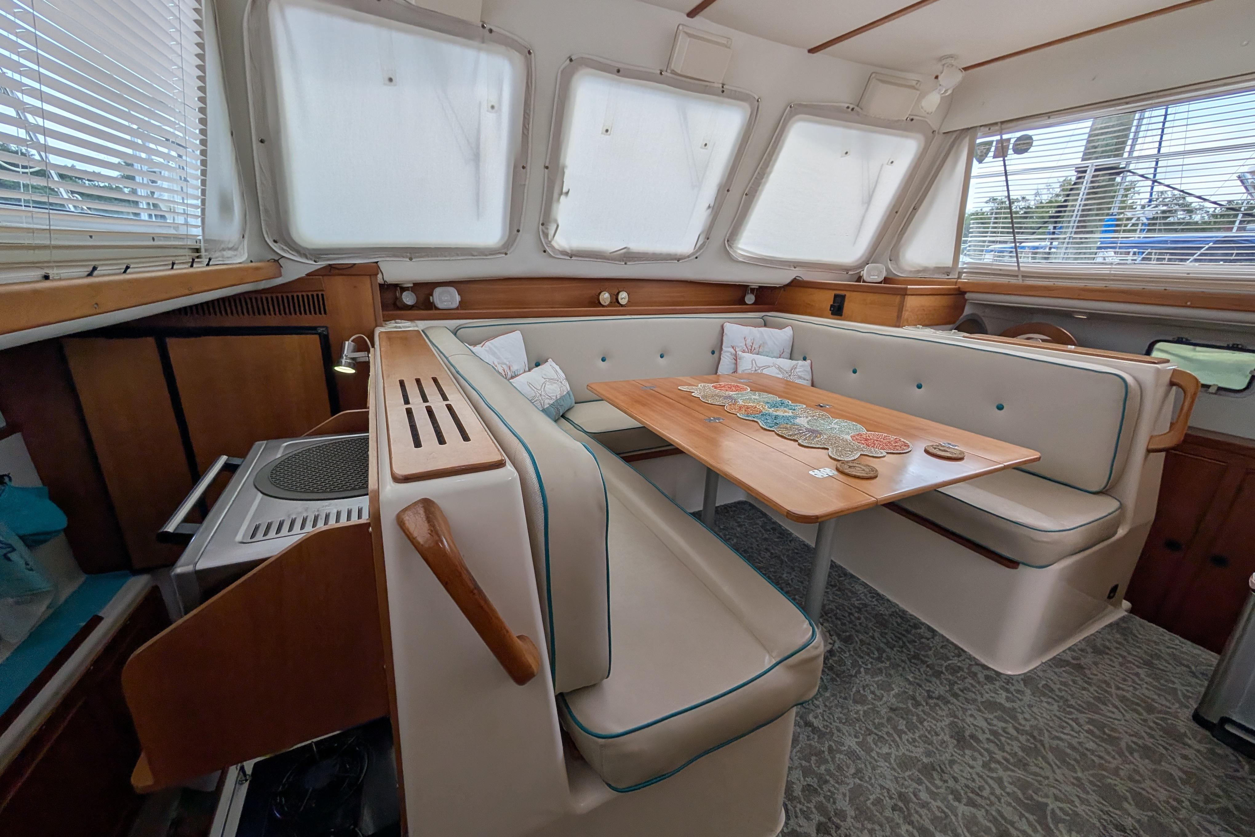 Interior of 2004 PDQ 34 Powercat with cozy seating and wooden table.