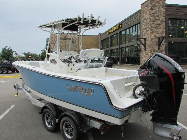 2023 Mako 214 CC boat on a trailer outside a sporting goods store.