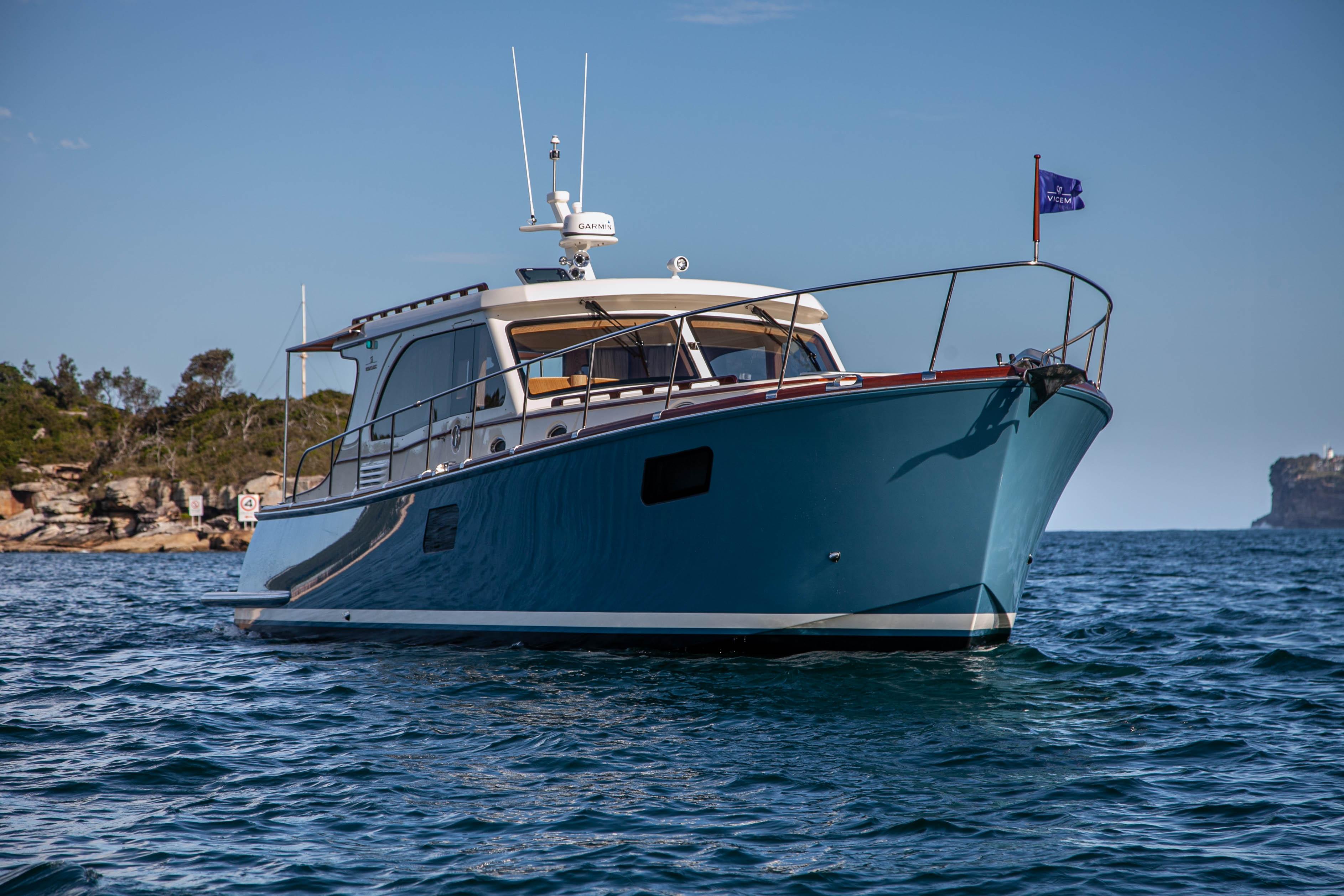 2023 Vicem 55 yacht on calm water, clear sky, coastal background.